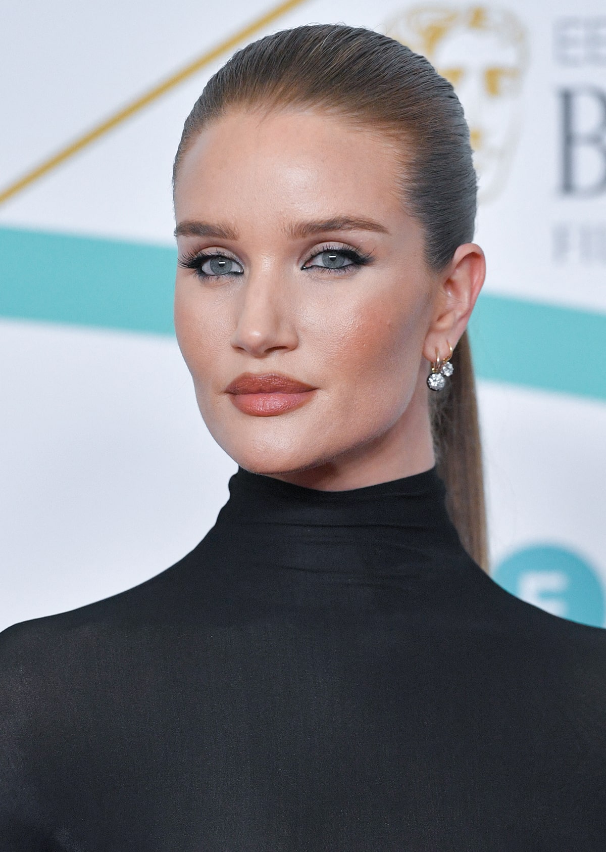 Rosie Huntington-Whiteley keeps the look sleek with a tight ponytail and sultry eyeliner