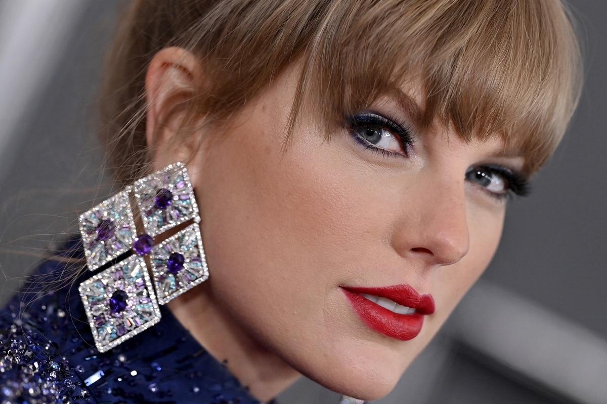 Taylor Swift paired the outfit with jaw-dropping sapphire and diamond earrings, red lips, and blue eyeshadow for makeup