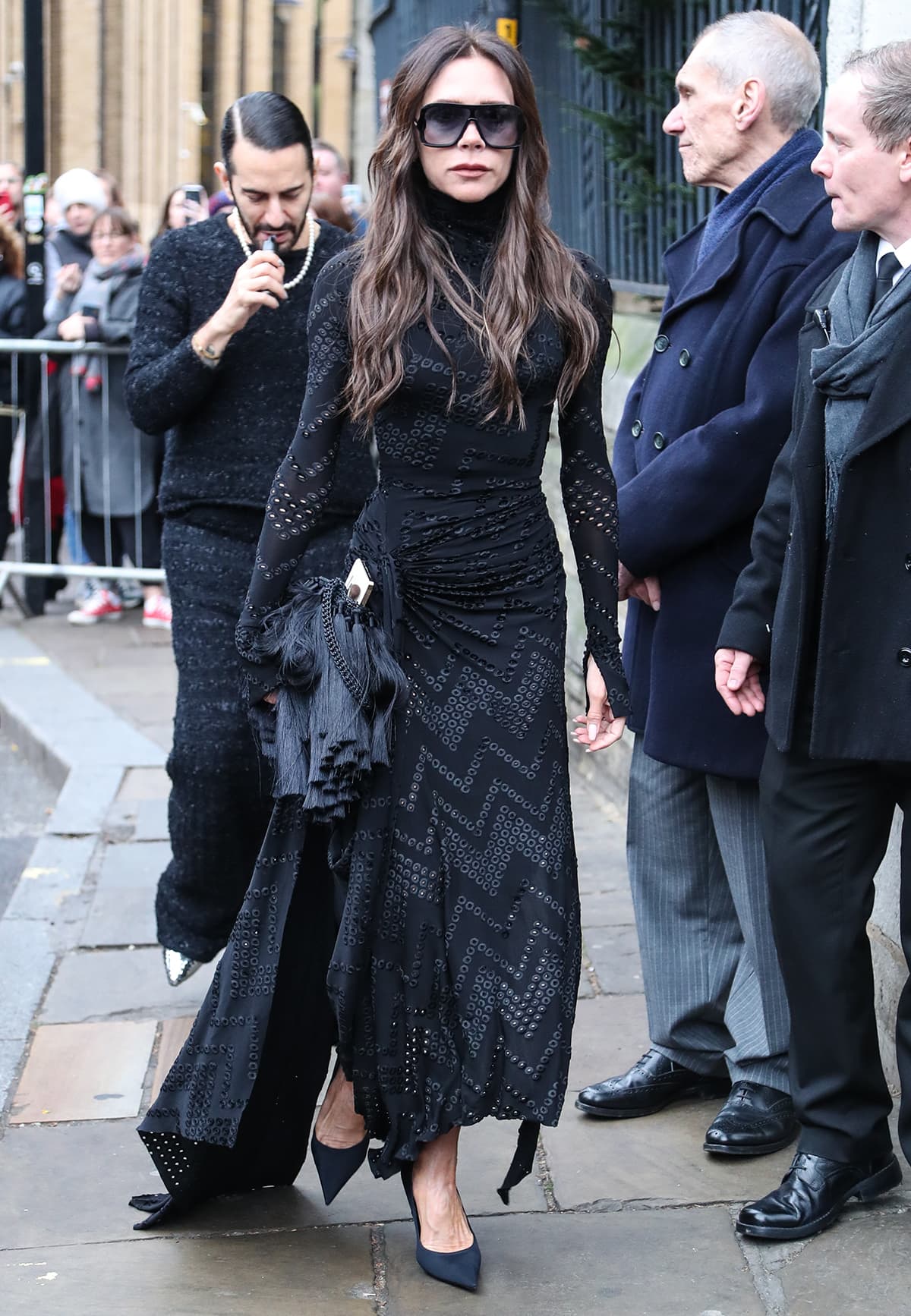 Victoria Beckham pays tribute to Vivienne Westwood in an eyelet-embroidered long-sleeved dress with a hankie hem and a pair of pointy pumps