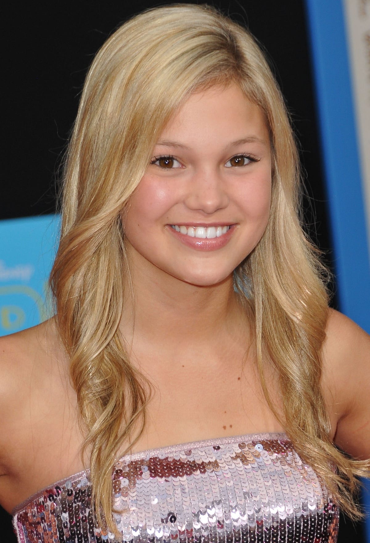 Olivia Holt shines in a sparkling sequin dress, embracing a youthful and glamorous look