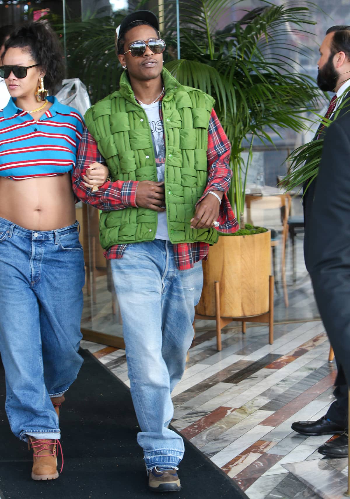 Rihanna's partner A$AP Rocky opted for a casual look, wearing baggy jeans and a red plaid shirt with a light-green Bottega Veneta intrecciato puffer vest