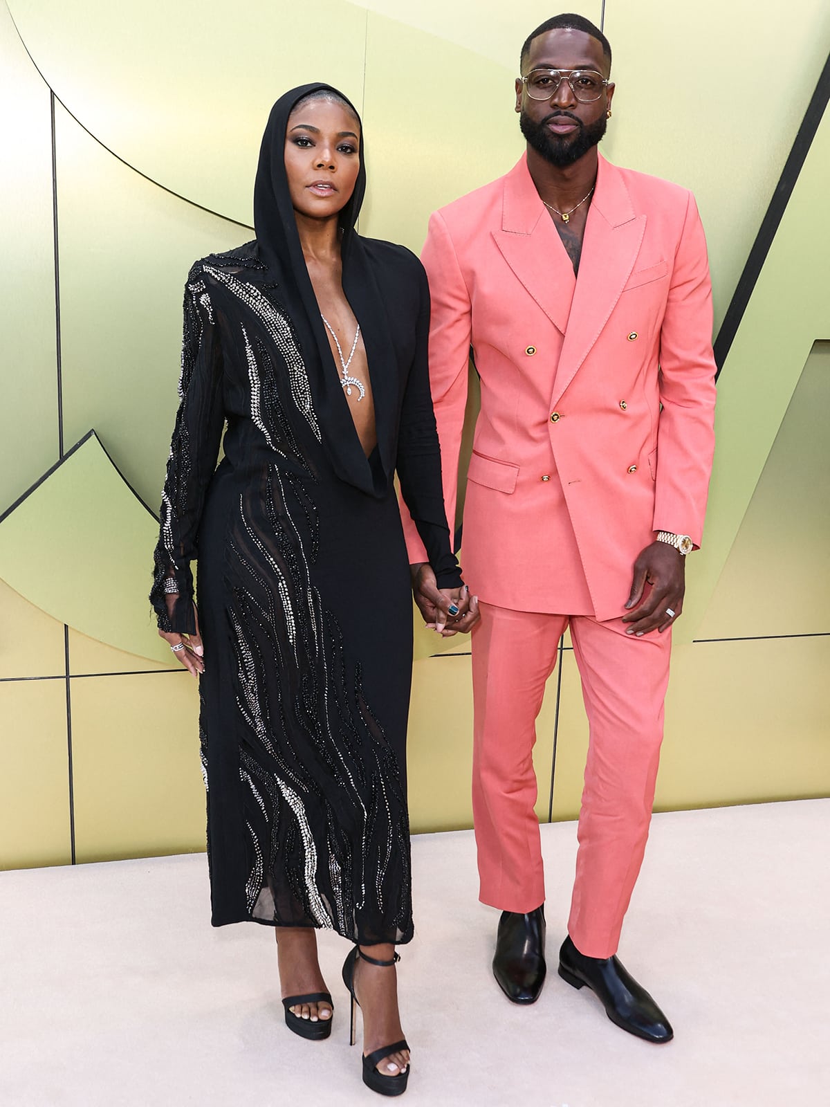 Dwayne Wade joins his wife Gabrielle Union on the red carpet in a salmon pink Versace suit