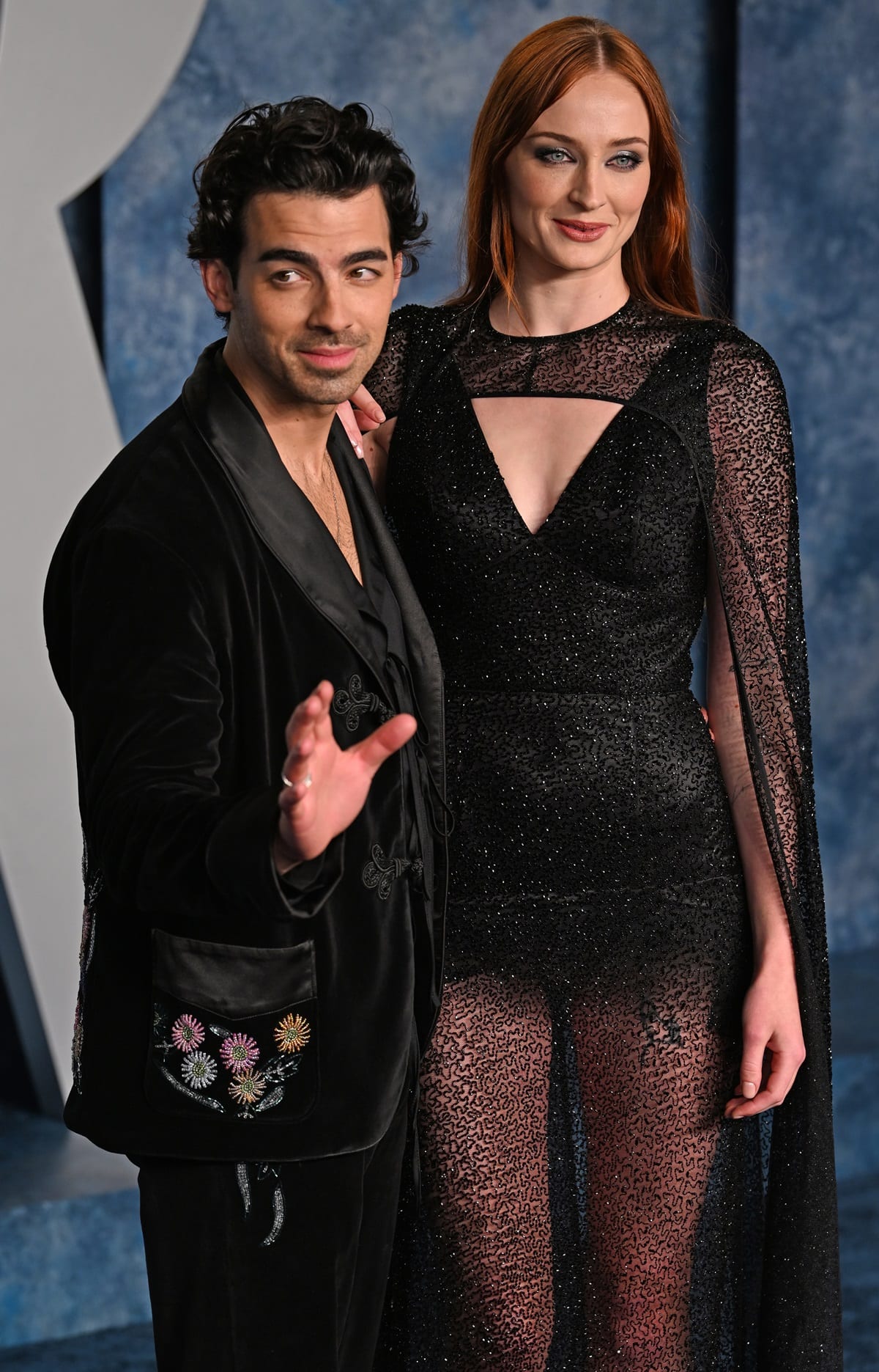 While Joe Jonas sported a black velvet suit with floral decorations on his pockets and ankles, Sophie Turner wore a dazzling sheer black dress with flowing caped shoulders