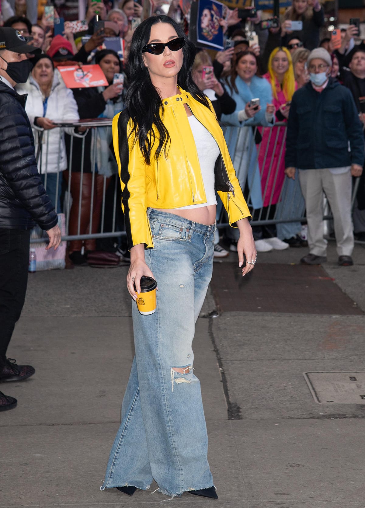 Katy Perry pairs her bright yellow moto jacket with a white ribbed crop top and a pair of R13 distressed baggy jeans