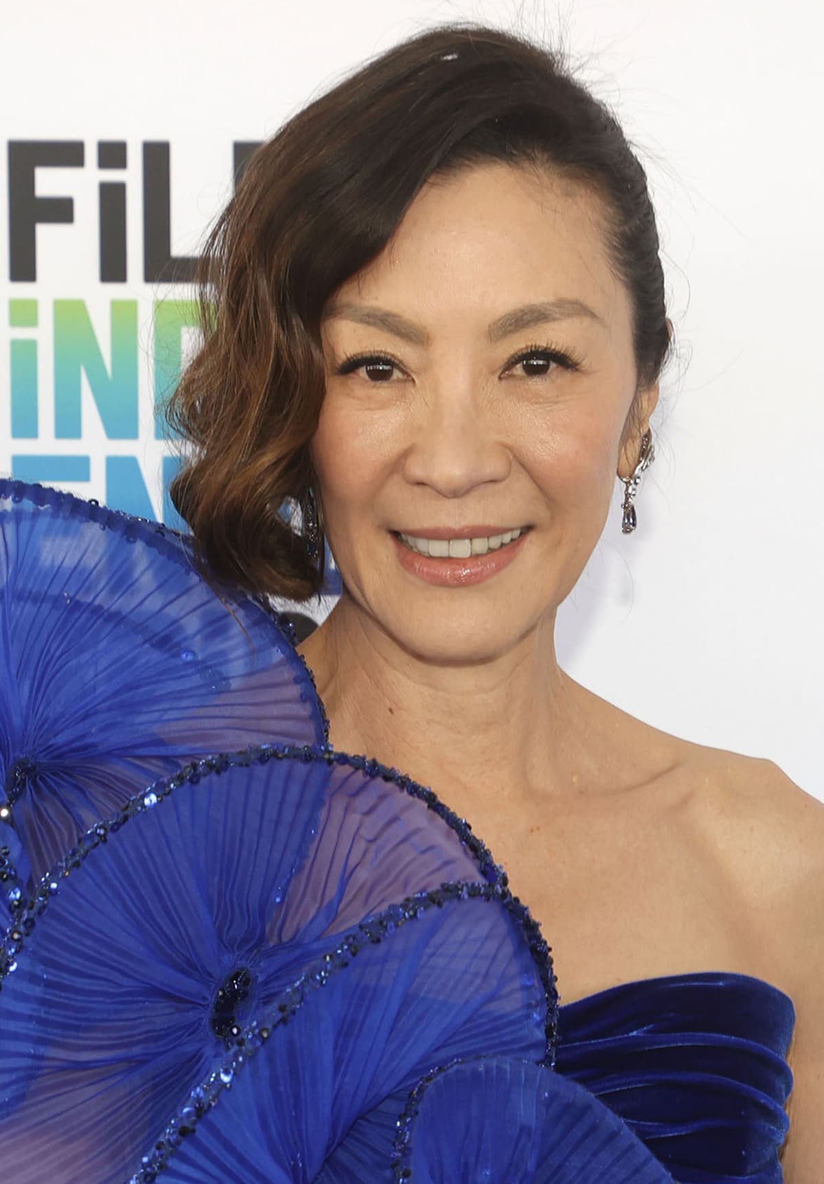 Michelle Yeoh wears soft retro curls and curled eyelashes with mascara and eyeliner