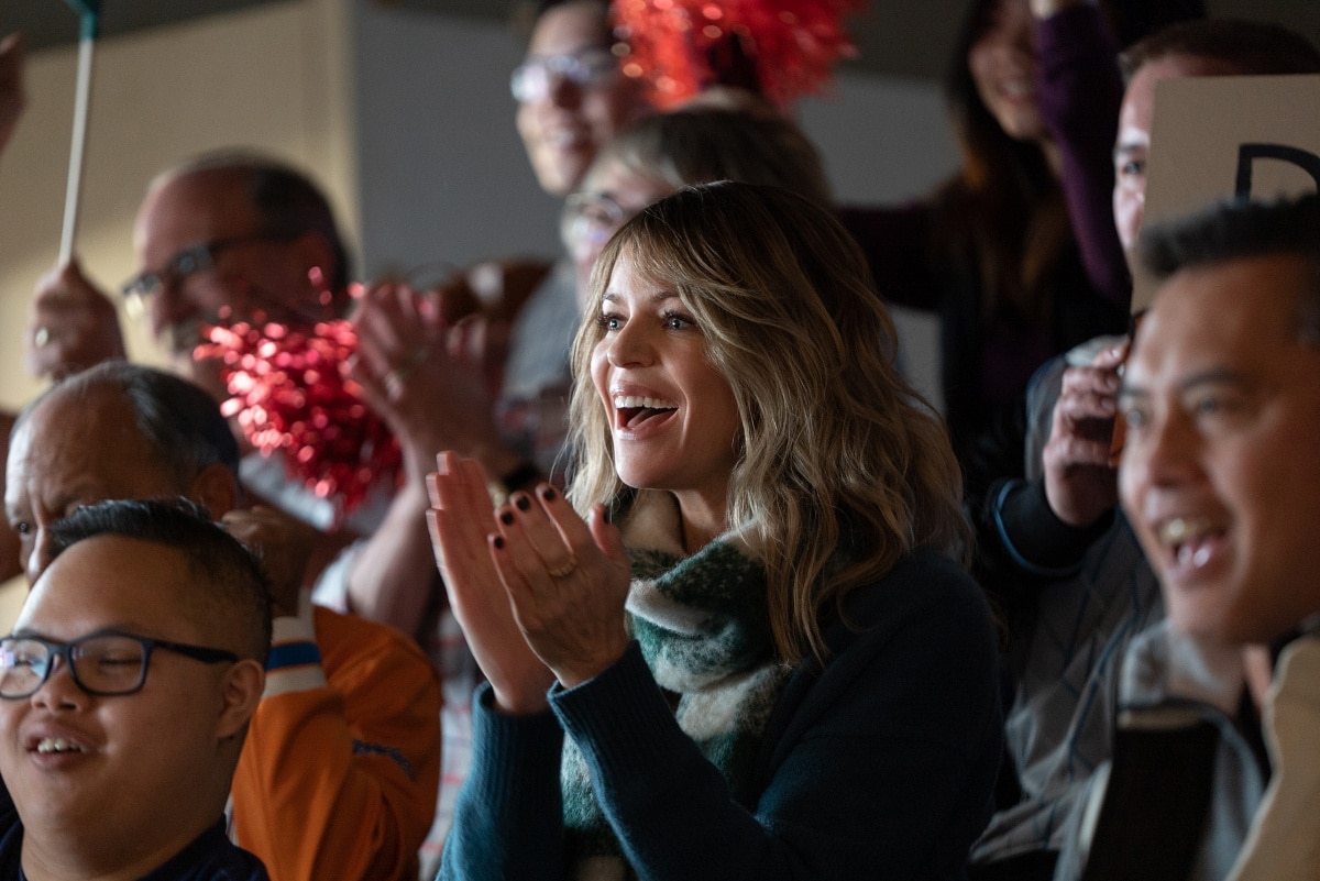 Kaitlin Olson enthusiastically cheers during a heartwarming scene from Champions, capturing the spirit of support and inclusion