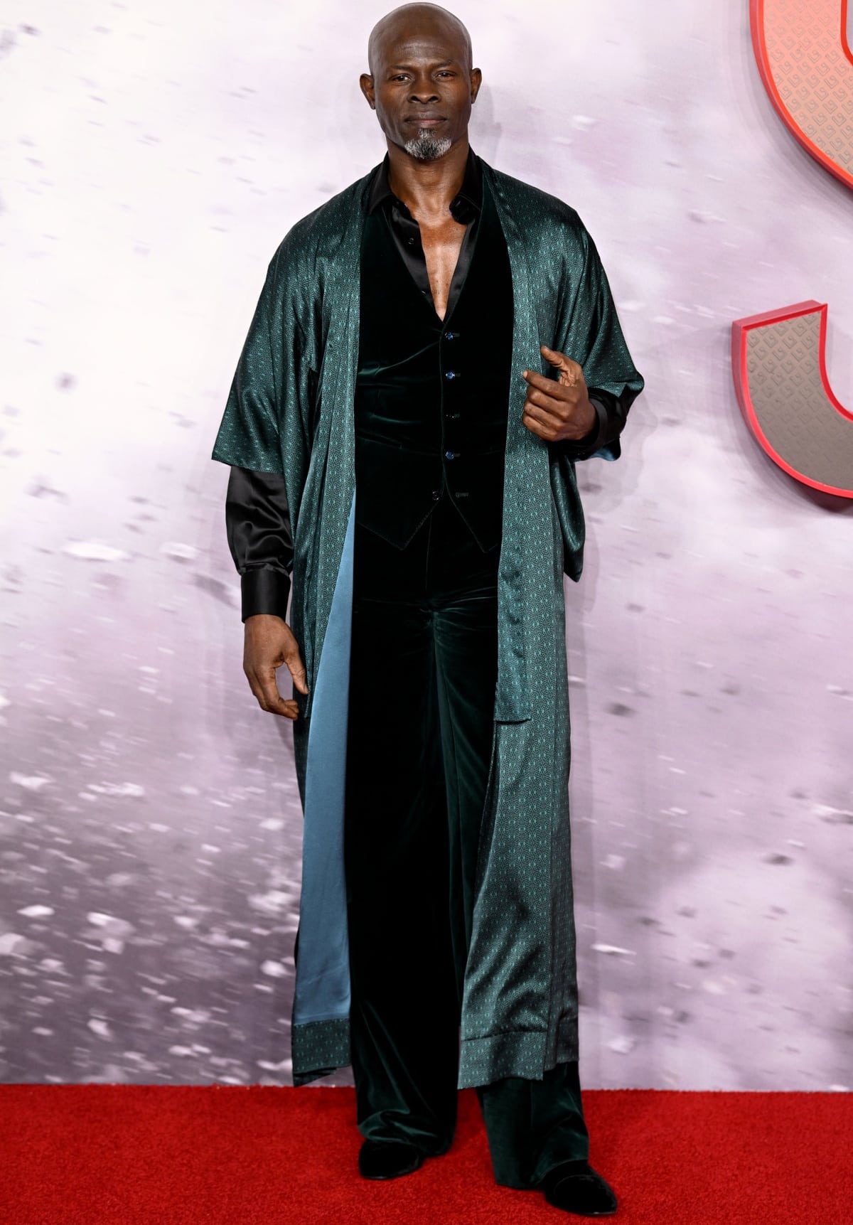 Djimon Hounsou makes a bold statement in a luxurious velvet suit and robe at the red carpet premiere of Shazam! Fury of the Gods