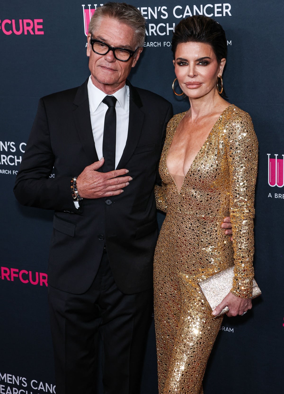 Harry Hamlin kept close to his wife at the event, wrapping his arm around Lisa Rinna’s waist as they posed for photographs together