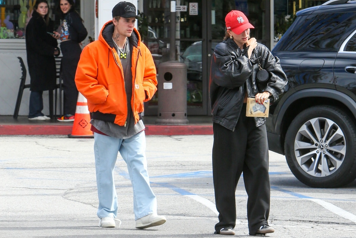 Justin Bieber was difficult to miss with his bright orange jacket, while Hailey Bieber accessorized with a red baseball cap to add a pop of color to her all-black ensemble