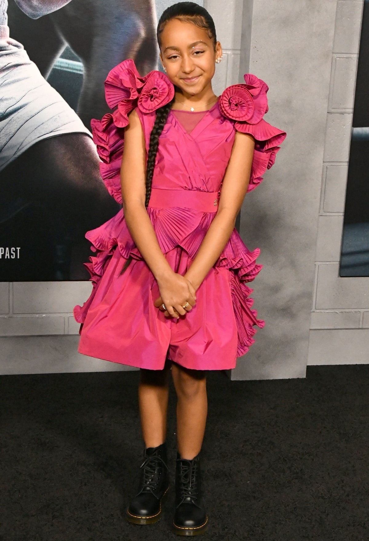 Mila Davis-Kent looking adorable in a pretty pink dress with black combat boots at the Los Angeles premiere of Creed III