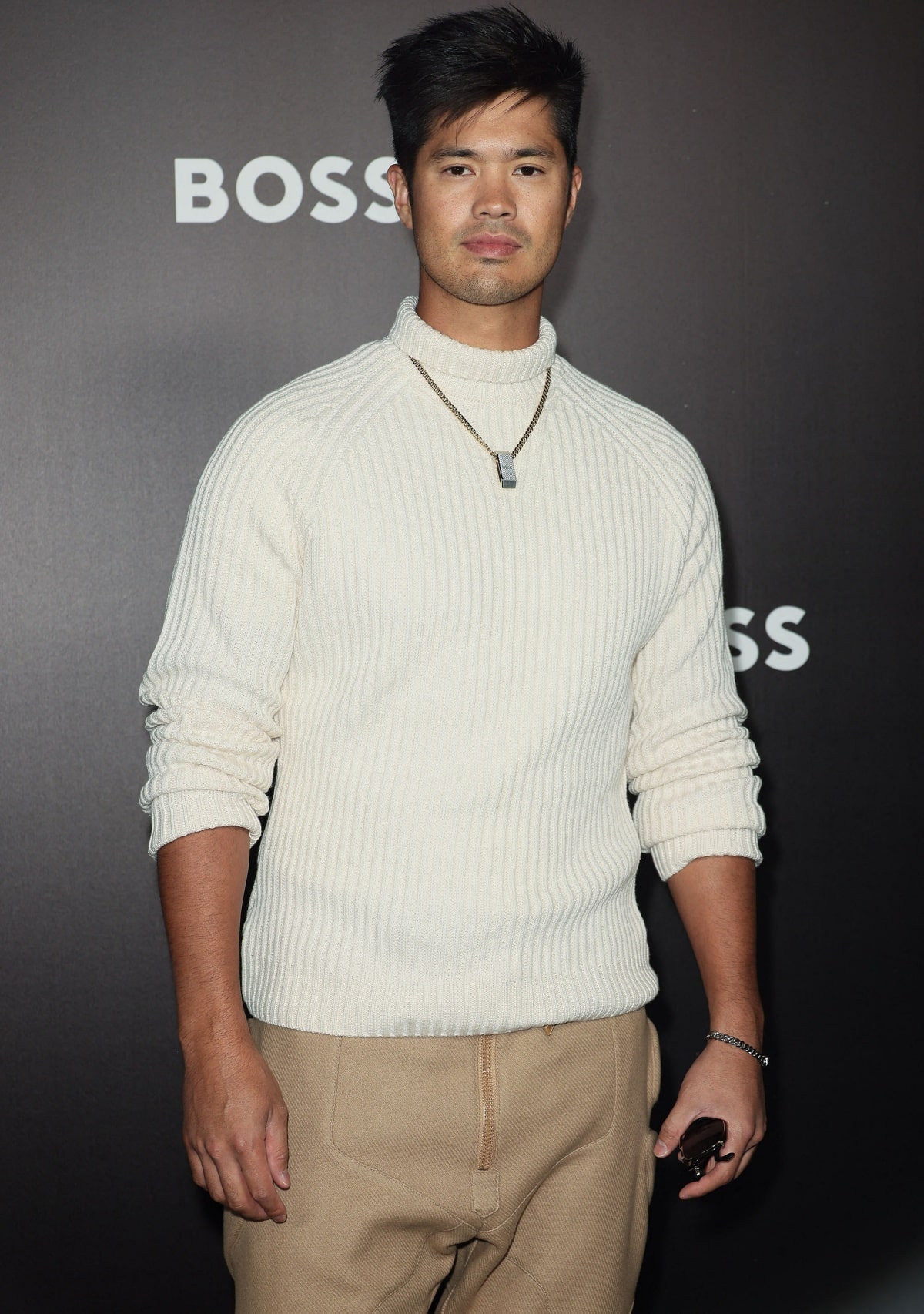 Ross Butler keeps it casual yet stylish in a cream knit sweater and beige pants at the Hugo Boss Spring/Summer 2023 show during Milan Fashion Week