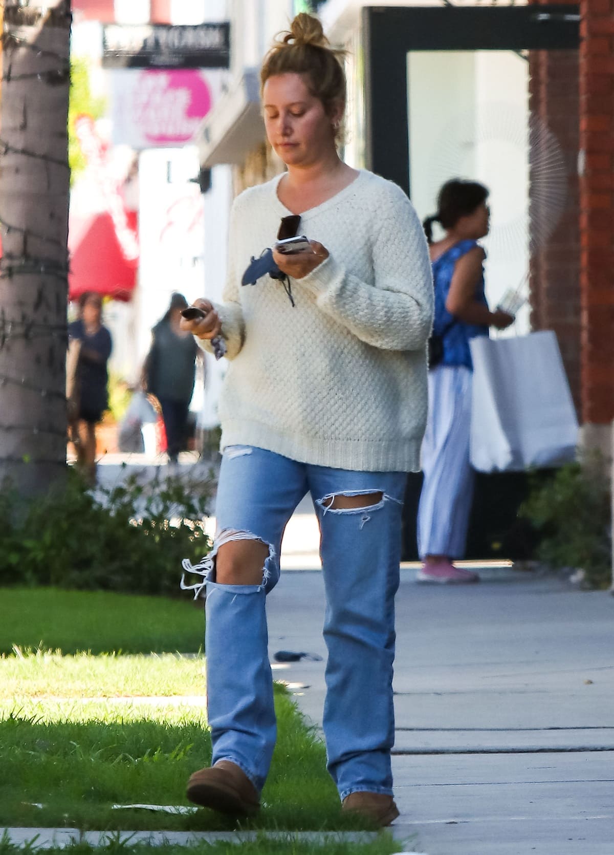 Ashley Tisdale wears ripped jeans with a white sweater