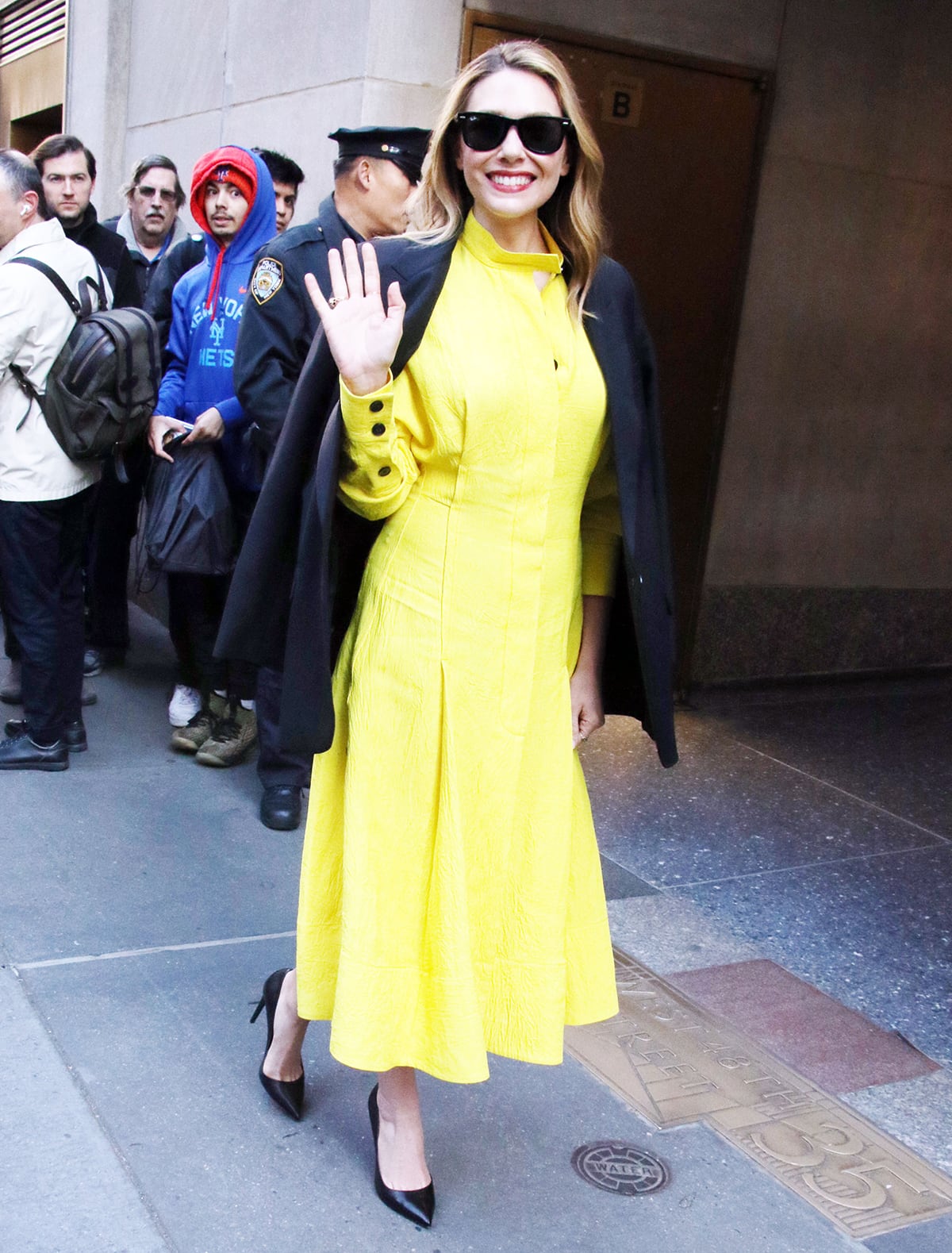 Elizabeth Olsen drops by the Today show in a sunshine yellow midi dress by Proenza Schouler to talk about her new series Love & Death on April 19, 2023