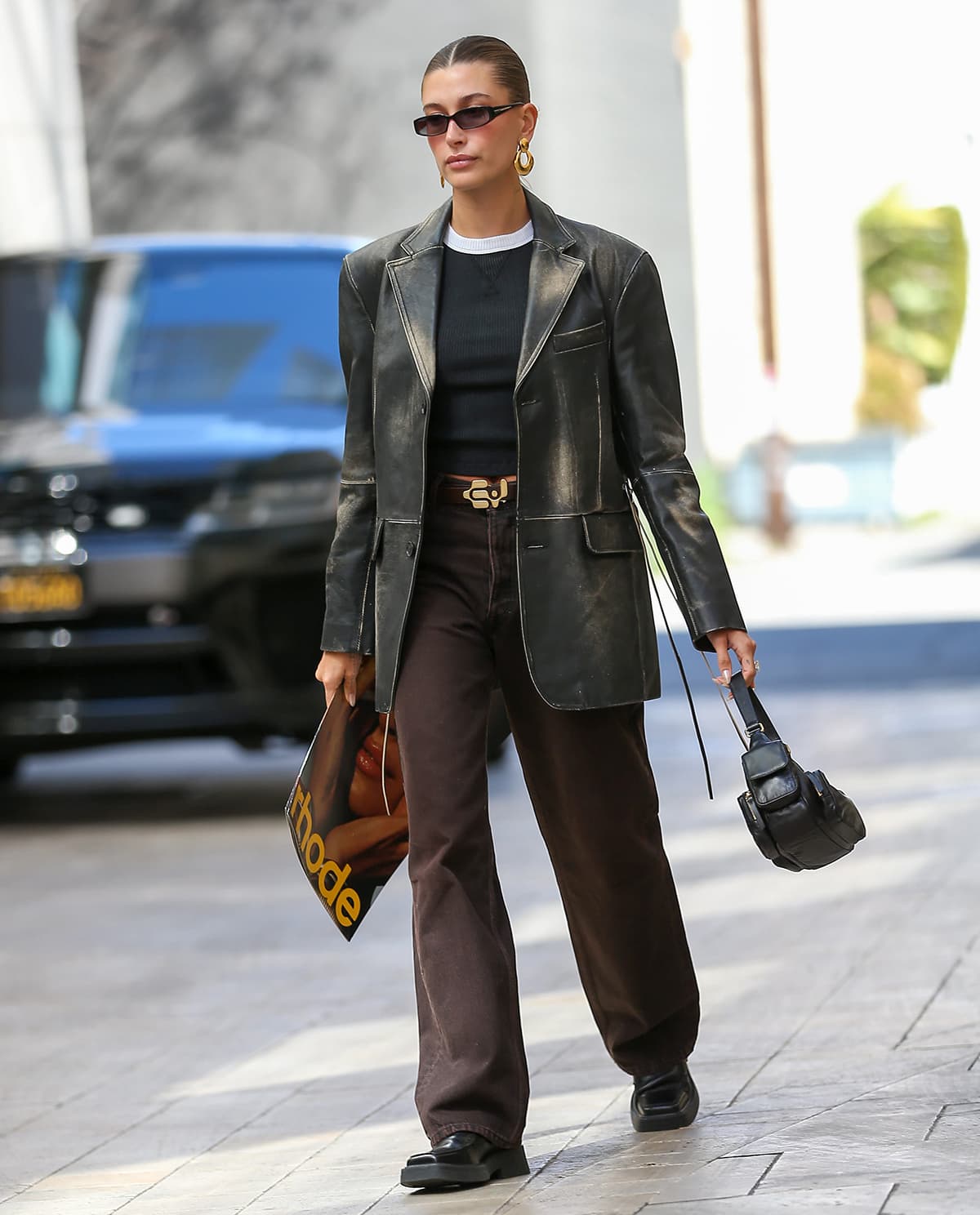 Hailey Bieber visits the Rhode Beauty office in Eytys leather blazer, brown jeans, and Marni loafers