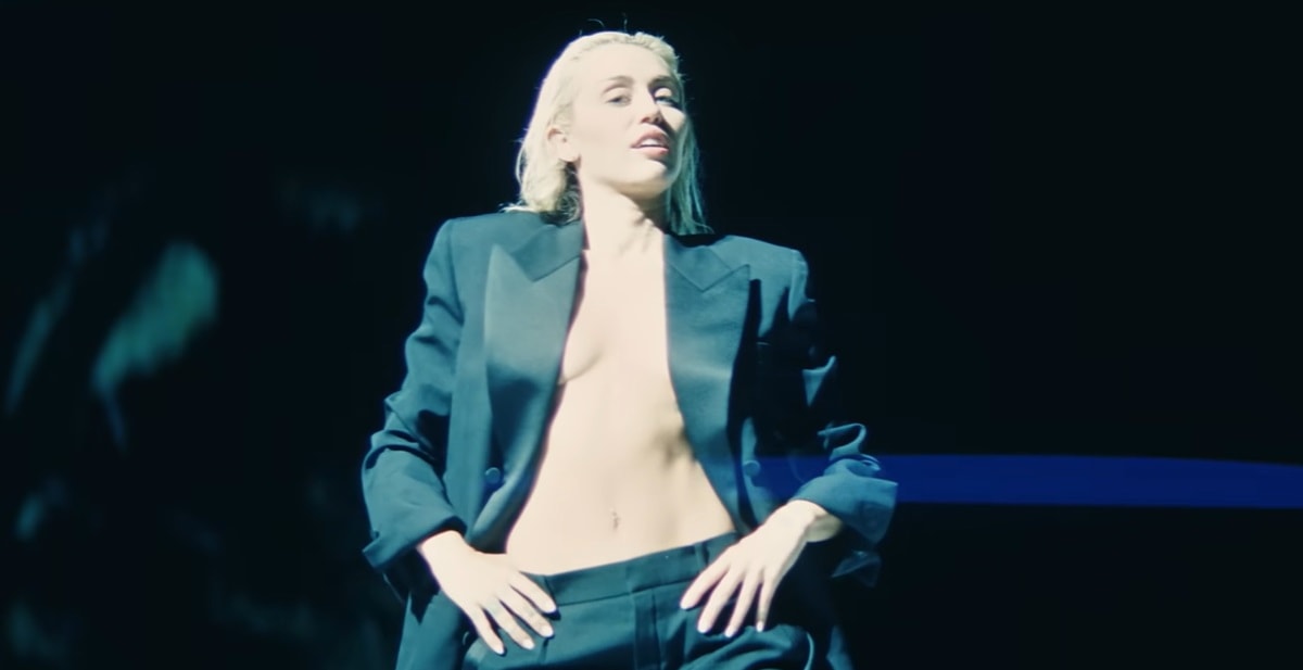 To wrap up the "Flowers" music video, Miley Cyrus dons a Saint Laurent satin lapel tuxedo, believed to be from the brand's autumn/winter 2022 collection