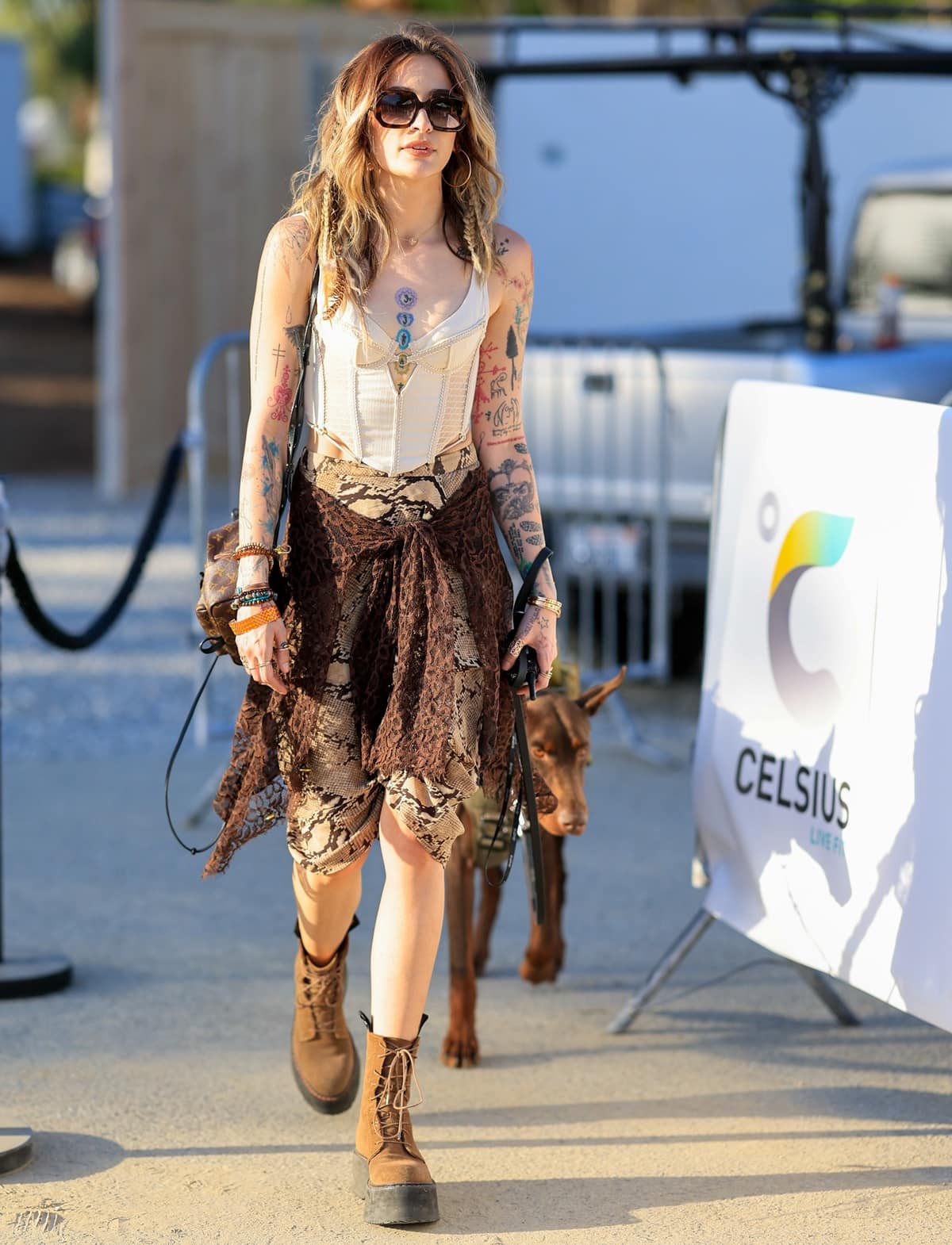 Paris Jackson showcased her signature blend of grunge and bohemian styles in a cream-colored structured corset top with see-through paneling paired with a high-waisted snakeskin-print skirt at the Celsius Coachella party