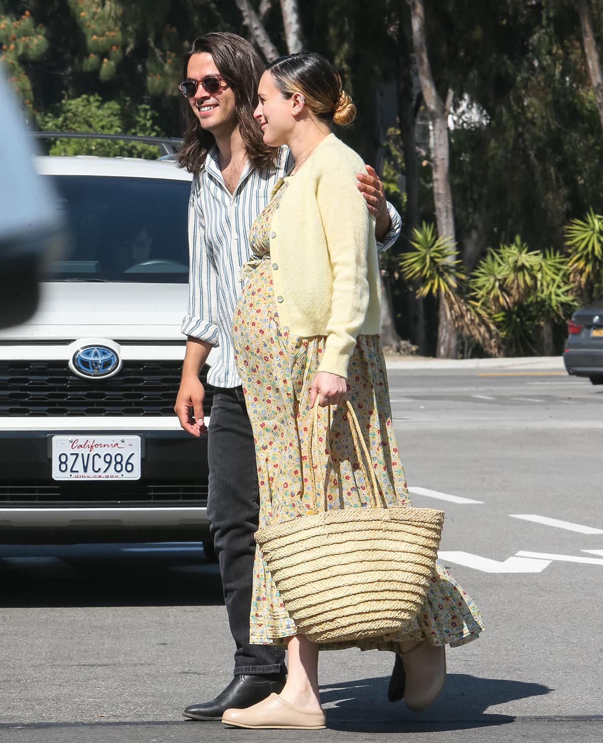 Rumer Willis showcases her growing baby bump in a yellow floral maternity maxi dress and a yellow cardigan