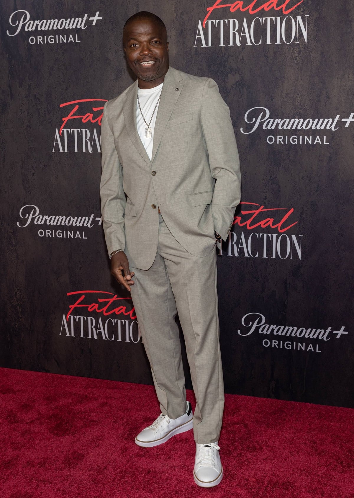 Reno Wilson keeps it effortlessly cool at the Fatal Attraction premiere, pairing a light gray suit with a casual white tee and stylish white sneakers for a relaxed yet polished look