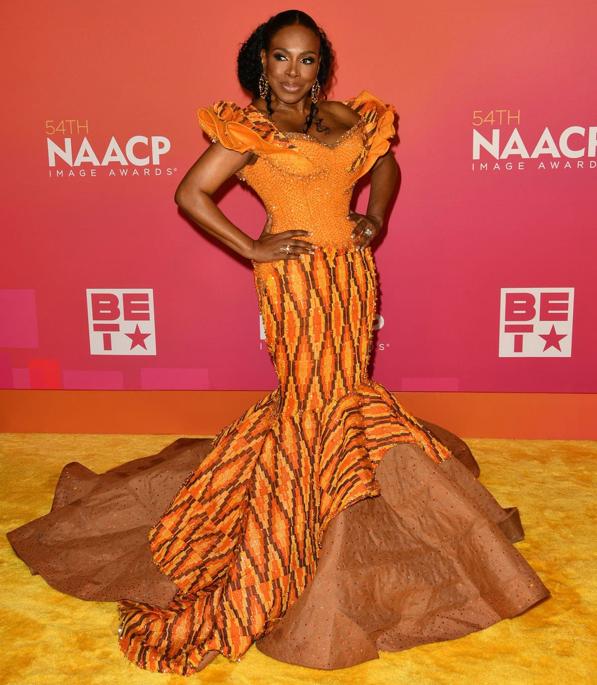 Sheryl Lee Ralph stuns in a vibrant beaded orange mermaid gown with ruffled sleeves and a dramatic train at the 54th NAACP Image Awards held February 25, 2023, at the Pasadena Civic Auditorium in Pasadena, California