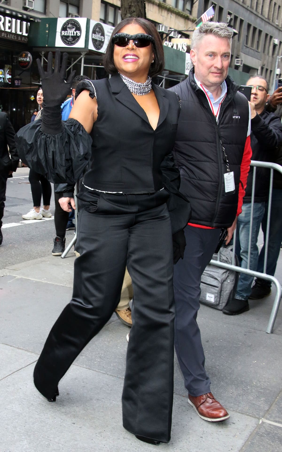 Taraji P. Henson arrived to tape an episode of The View in New York City in a black jumpsuit with a plunging neckline, voluminous elbow-length gloves, and a silver choker necklace
