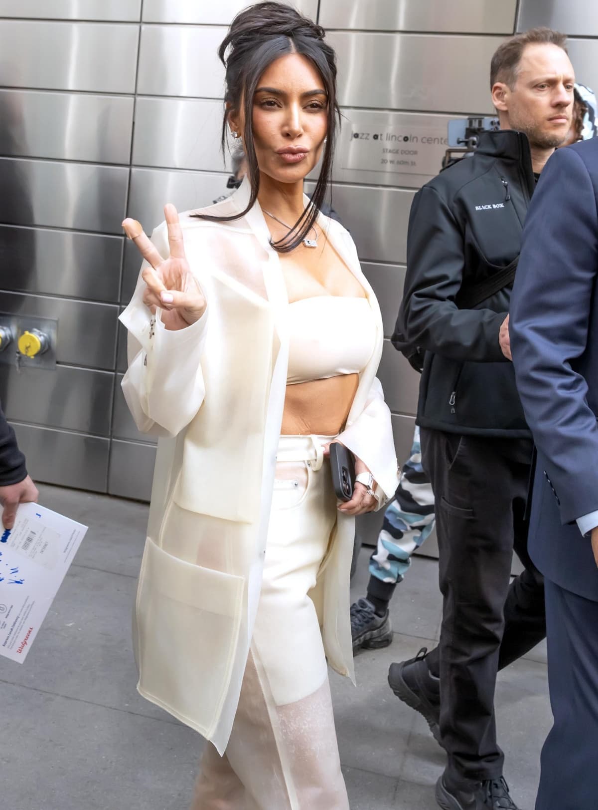 Kim Kardashian flashing a peace sign as she exits the Time100 Summit