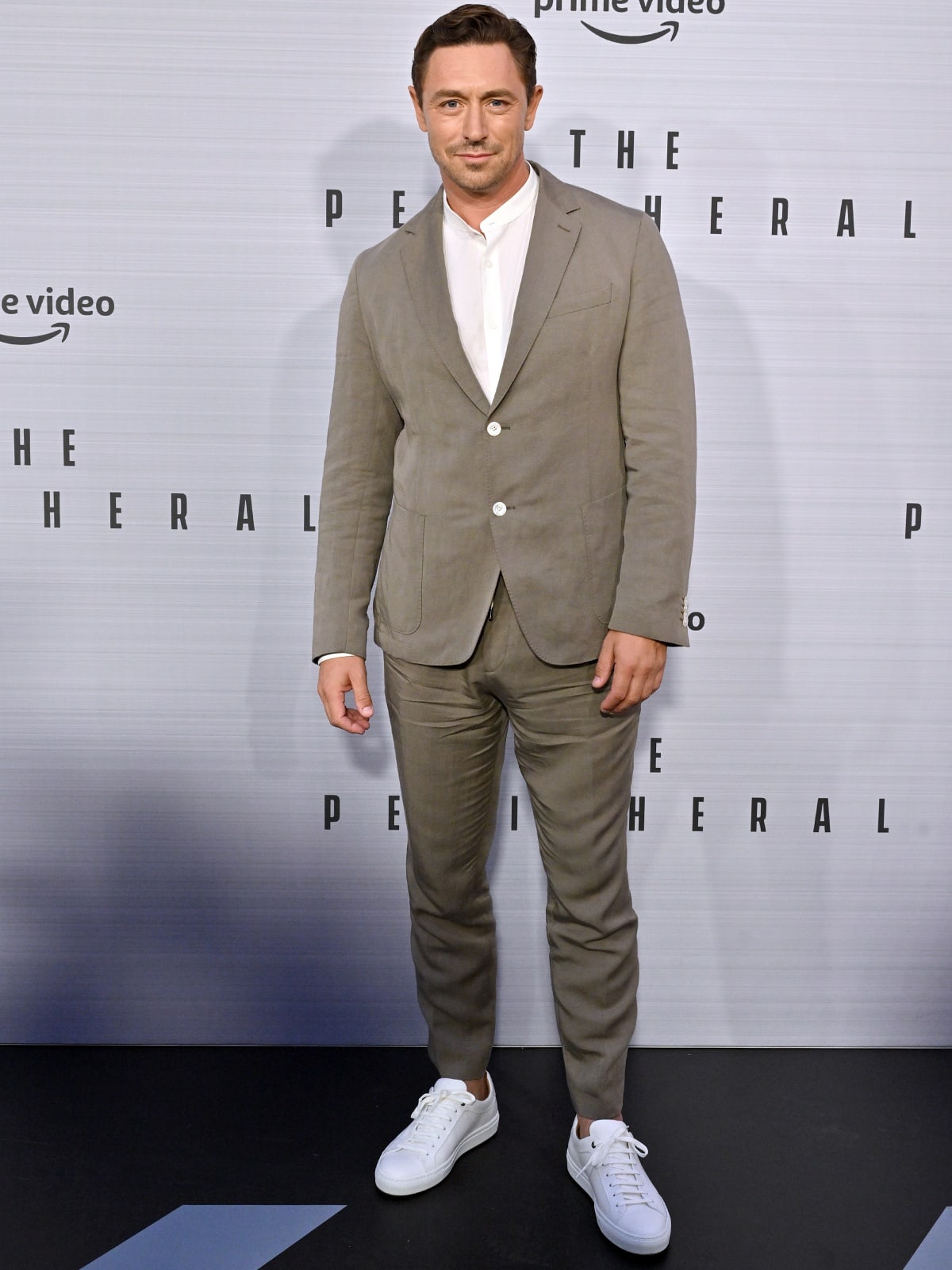 JJ Feild keeps it casual yet polished in a beige suit paired with crisp white sneakers at The Peripheral premiere