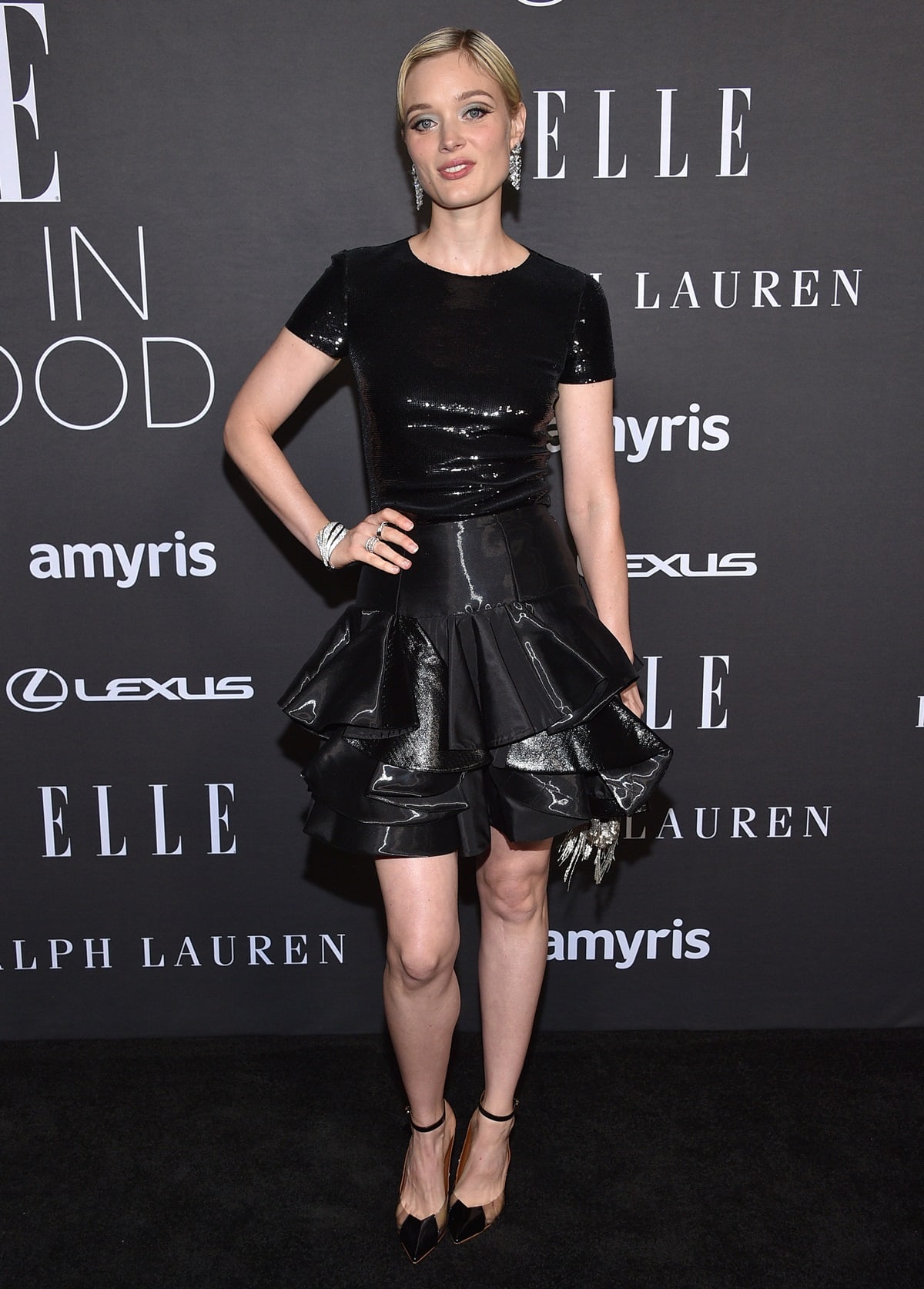 Bella Heathcote showcased an elegant Ralph Lauren Collection all-black ensemble, complemented by Malone Souliers Malia pumps and accessorized with a silver clutch and exquisite silver Cartier jewelry pieces at the 29th Annual ELLE Women in Hollywood Celebration
