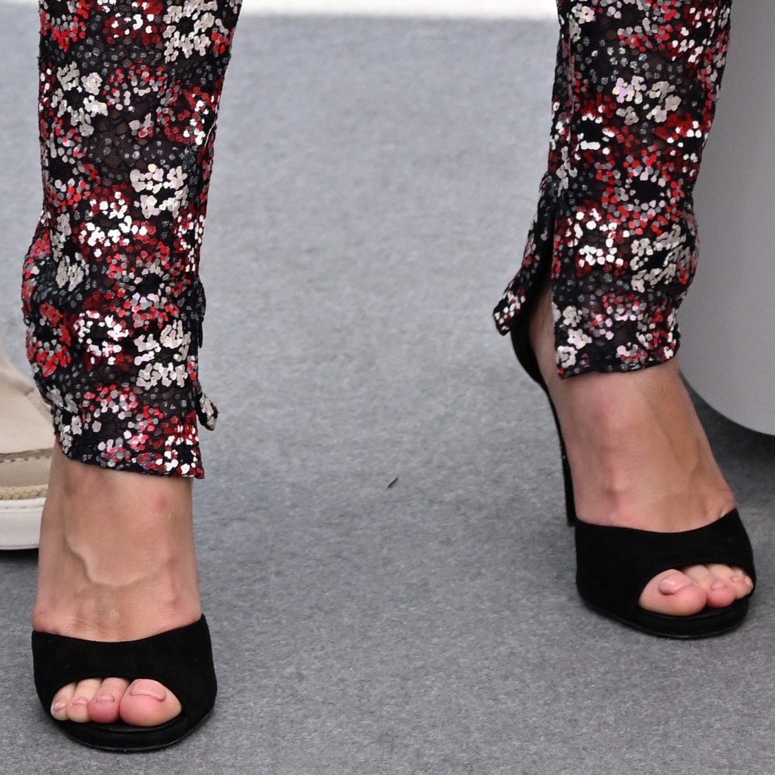Brie Larson shows off her feet in black sandals featuring an almond toe and a curved toe strap