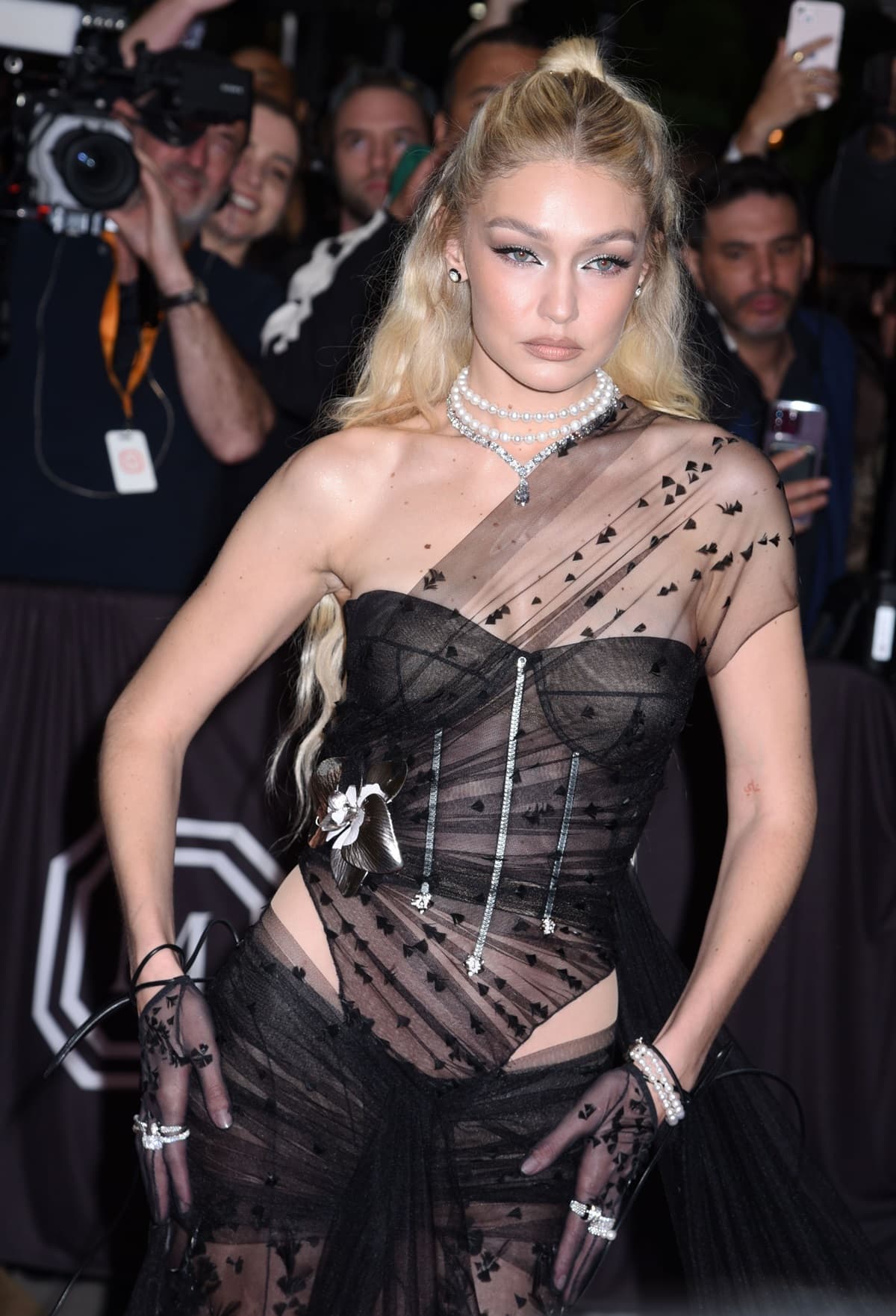 To complete the standout look, Gigi Hadid wore sheer black Calzedonia tights and accessorized with Lagos jewelry, including a pearl and diamond choker and diamond stud earrings