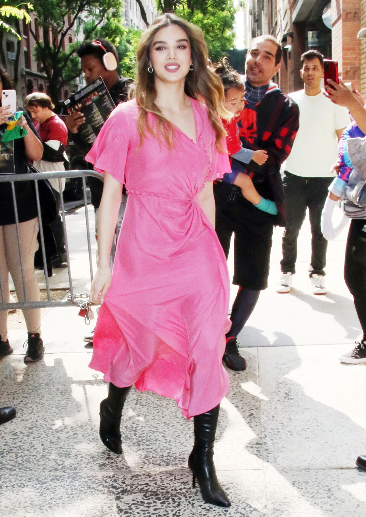 Hailee Steinfeld leaves the ABC studios in a Barbiecore pink asymmetrical dress by Prabal Gurung and black knee-high boots by Femme LA