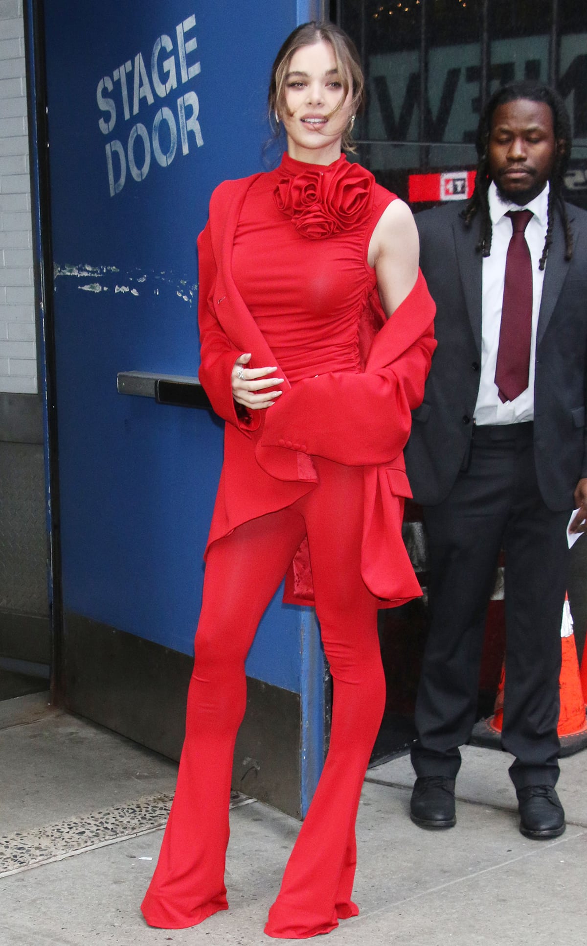 Hailee Steinfeld stuns in a red ruched sleeveless top with matching flared trousers and an oversized jersey blazer
