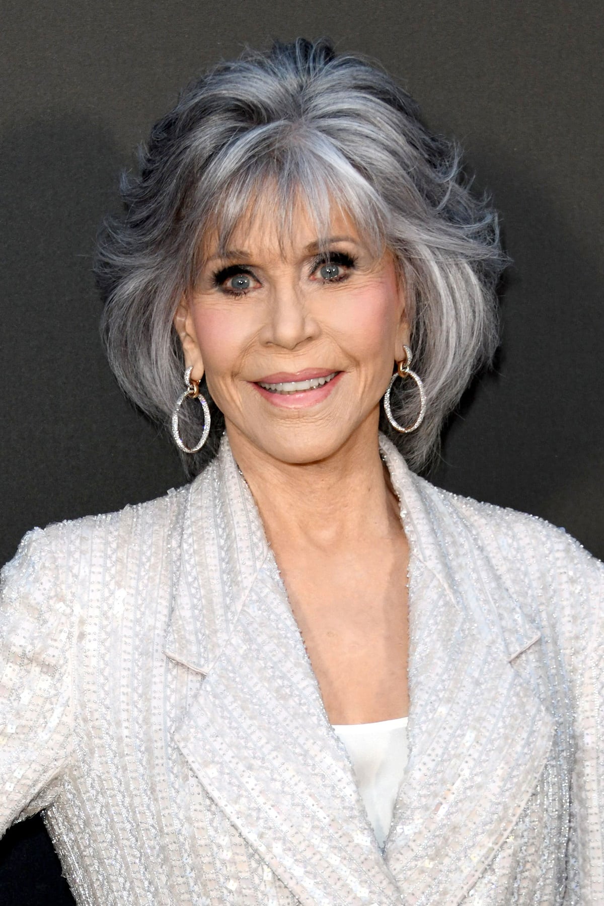 Jane Fonda adorned her ears with dangling diamond-encrusted earrings and styled her hair in an elegant, quaffed style