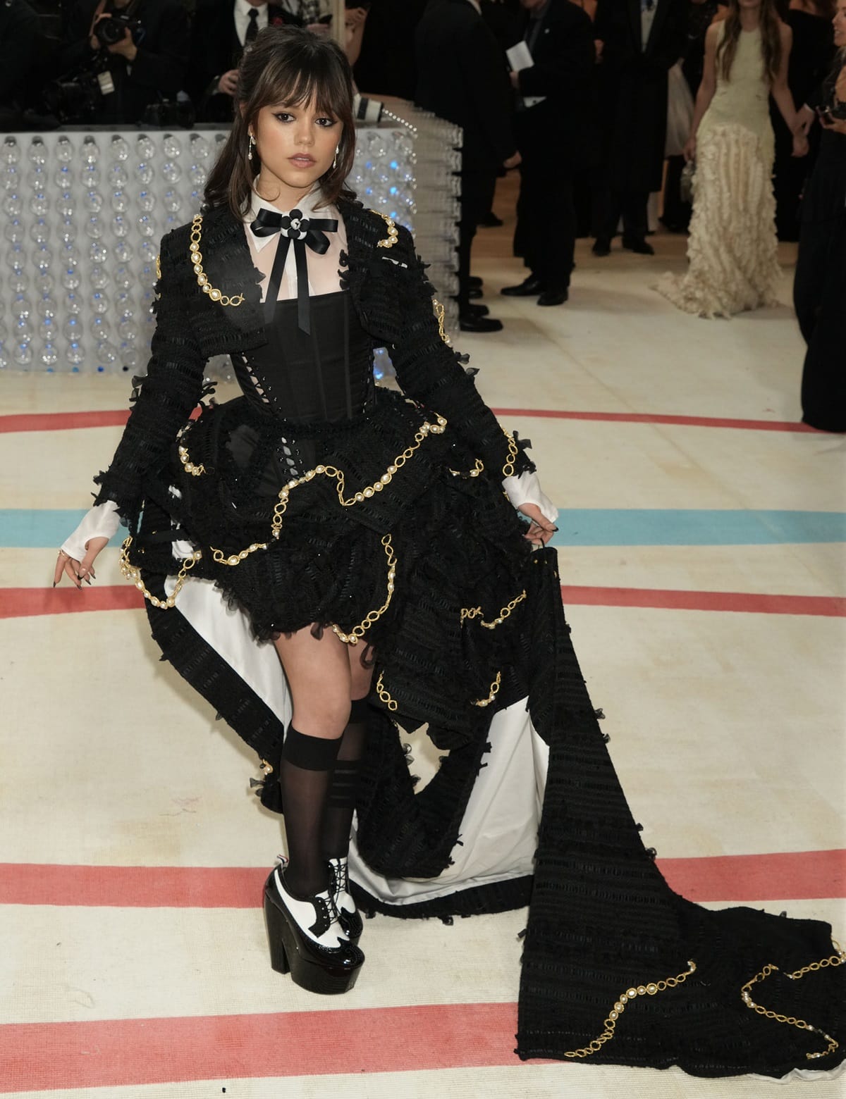 To complete her outfit, Ortega chose to wear Thom Browne’s signature towering Oxford heels boasting glossy black and white color-blocked uppers with classic wingtip detailing