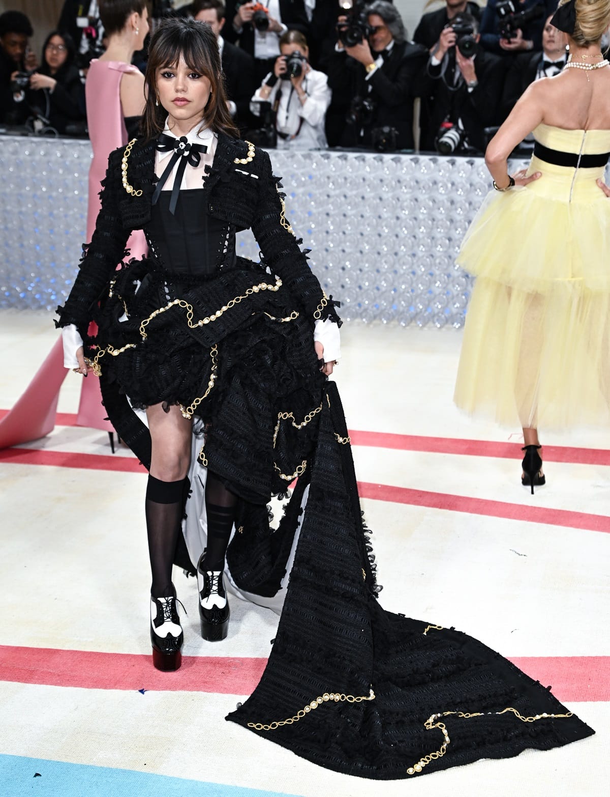 Jenna Ortega made a statement at the 2023 Met Gala by putting a whimsical spin on classic suiting with a nod to Karl Lagerfeld, reminiscent of her character Wednesday Addams from Netflix’s Wednesday