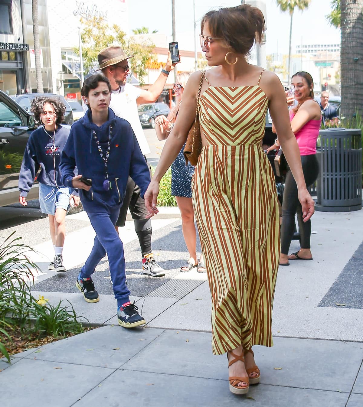 Joined by her twins Emme Maribel Muñiz and Maximilian David Muñiz, Jennifer Lopez styled her Venroy apron summer dress with Minel sandals from her fashion collaboration with DSW