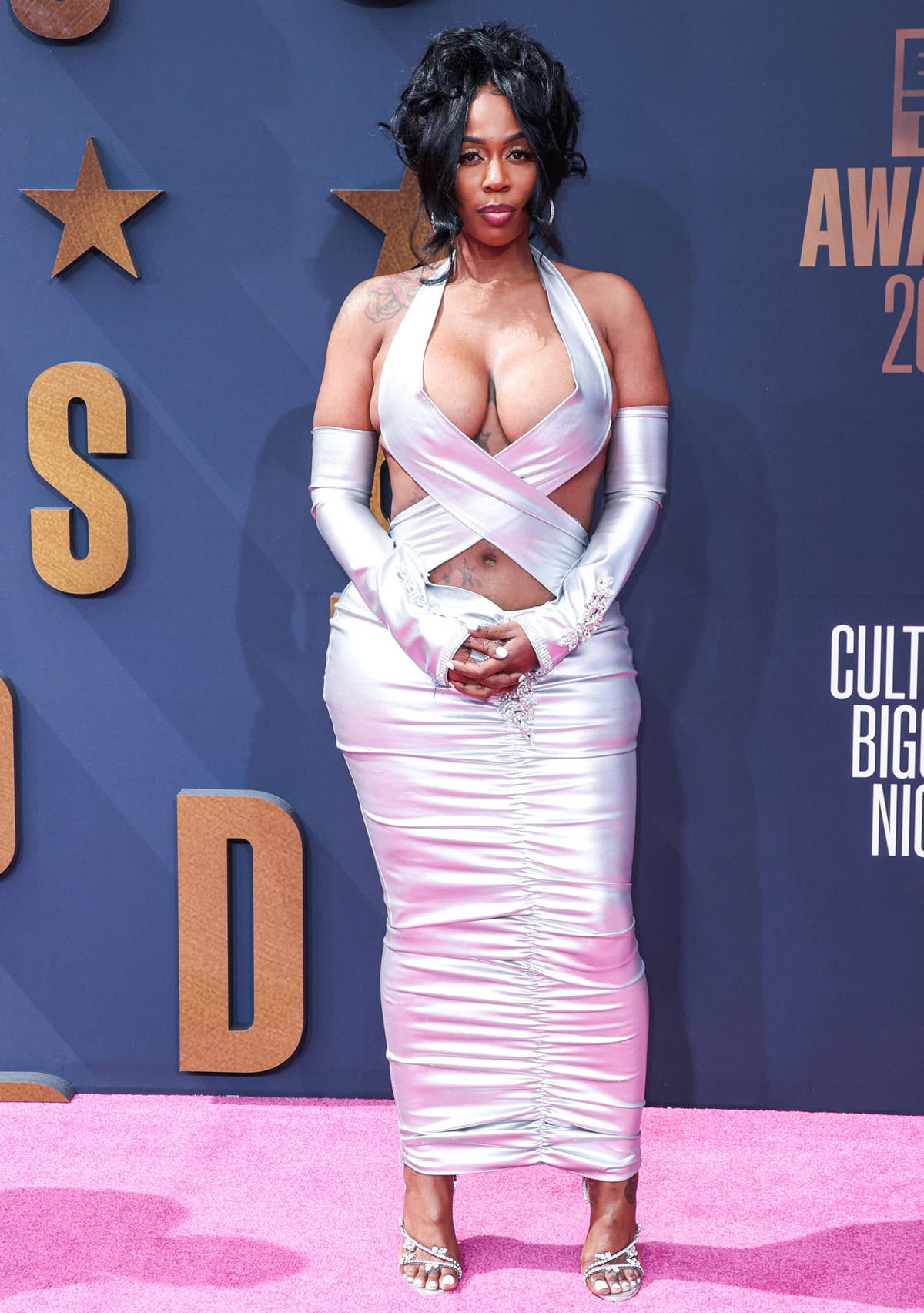 Kash Doll stunned in a satin pink halter dress by Fly Shit Only, paired with crystal-embellished Christian Louboutin heels and matching opera gloves for a show-stopping glam look