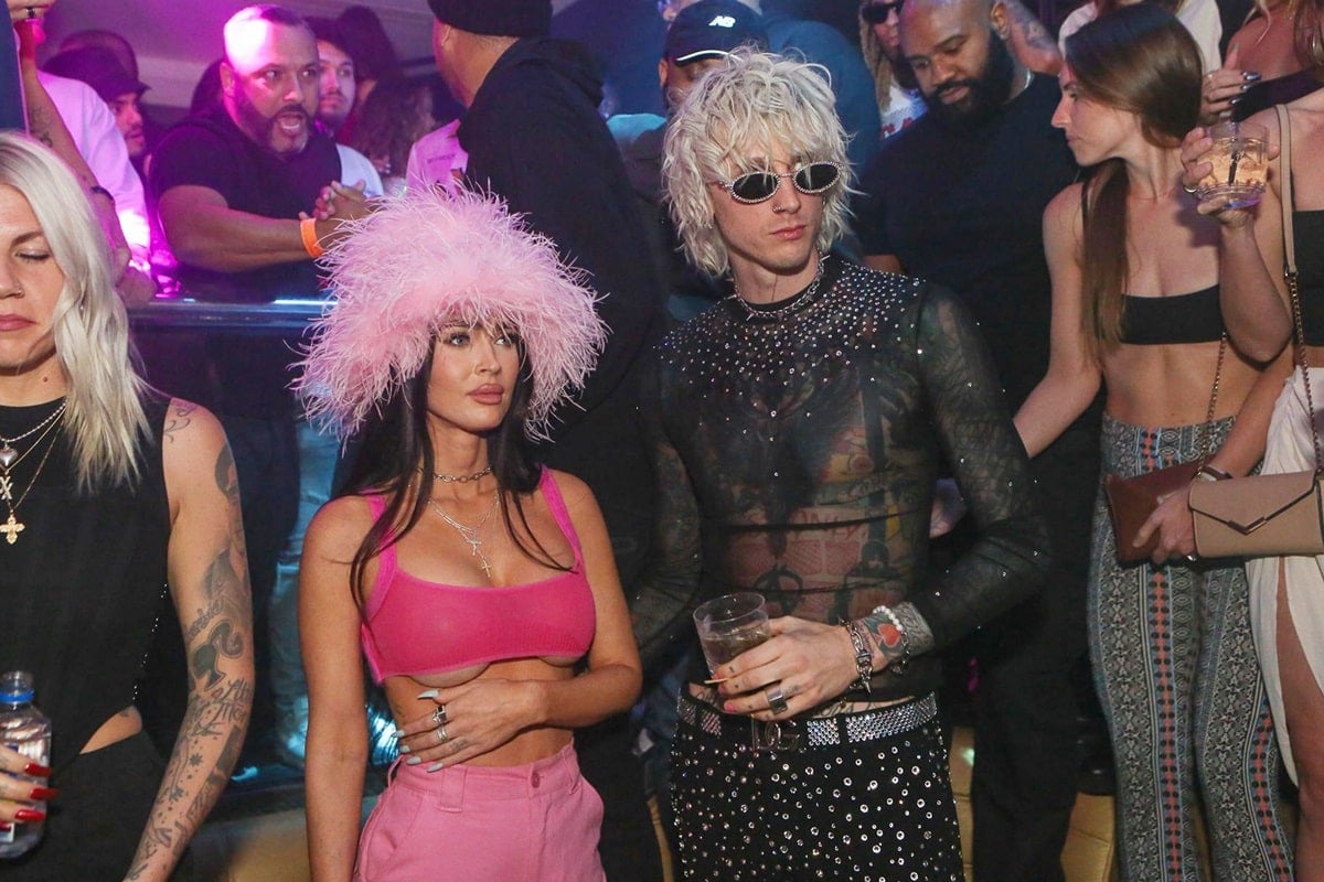 Megan Fox, wearing a striking cotton candy-colored furry hat and a micro-top, and Machine Gun Kelly are seen at E11EVEN Miami during Miami Art Week