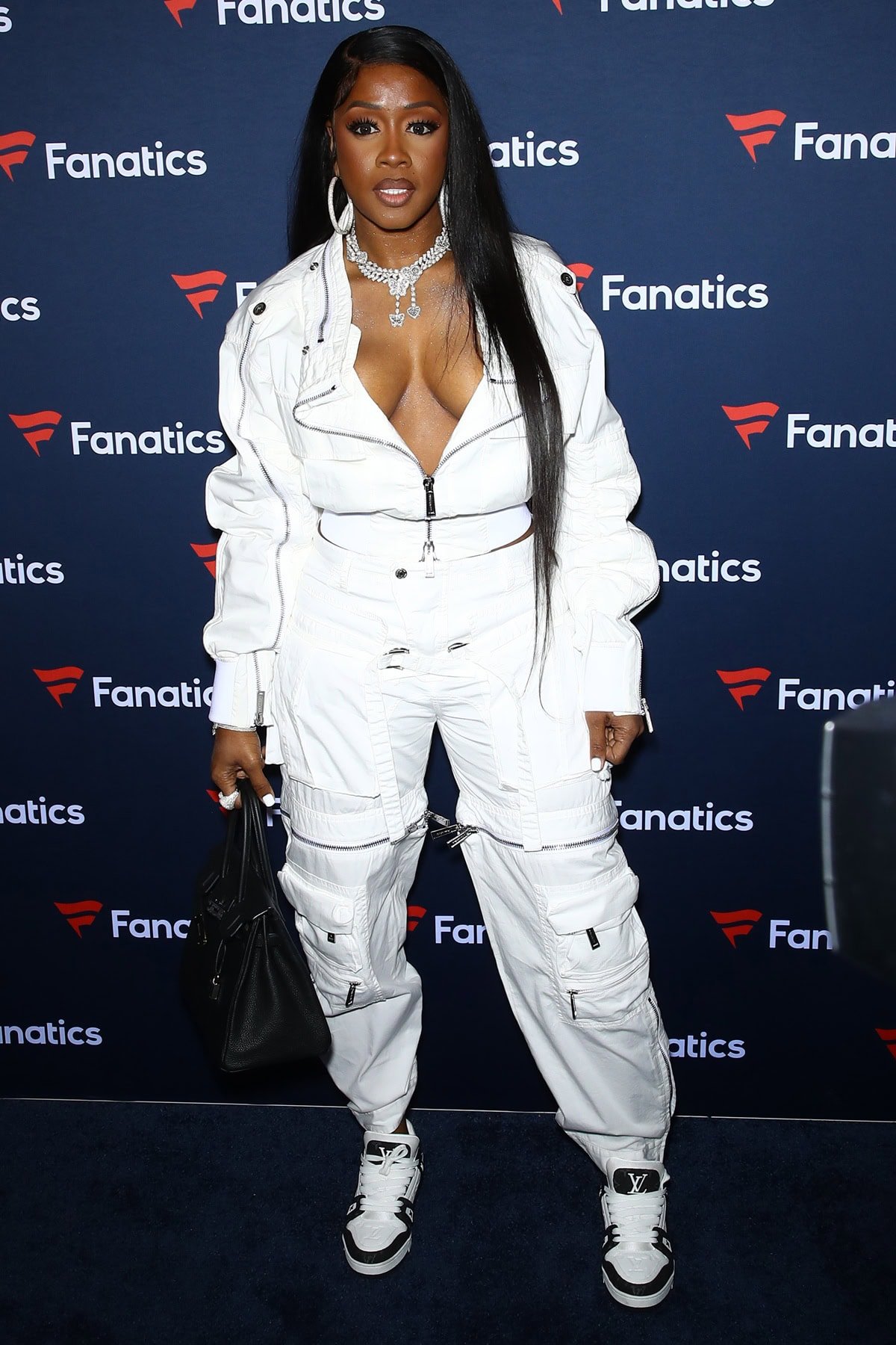 Remy Ma rocked an edgy all-white zip-front cargo jumpsuit with Louis Vuitton sneakers and a structured black handbag at Michael Rubin's Fanatics Super Bowl Party in Las Vegas on February 10, 2024