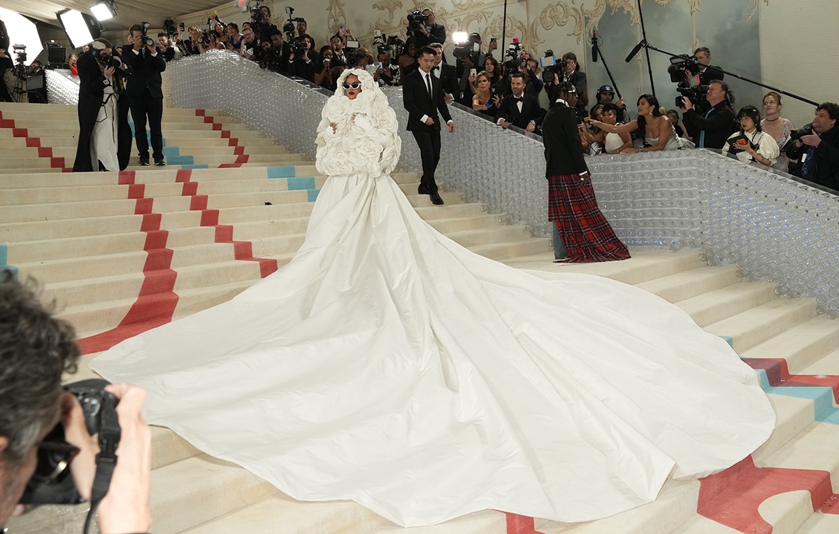 Rihanna wearing a white Valentino bridal gown with a 3D camellia flower-embroidered hooded cape and a 5-meter-long train