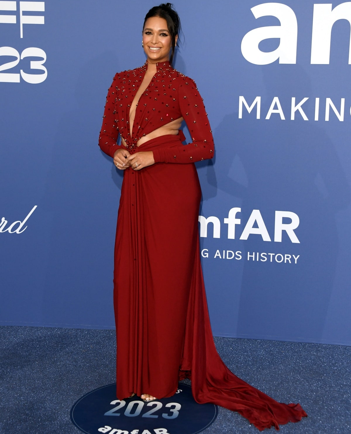 April Love Geary looking stunning in a dark red dress with sultry cut-out detailing and a plunging neckline