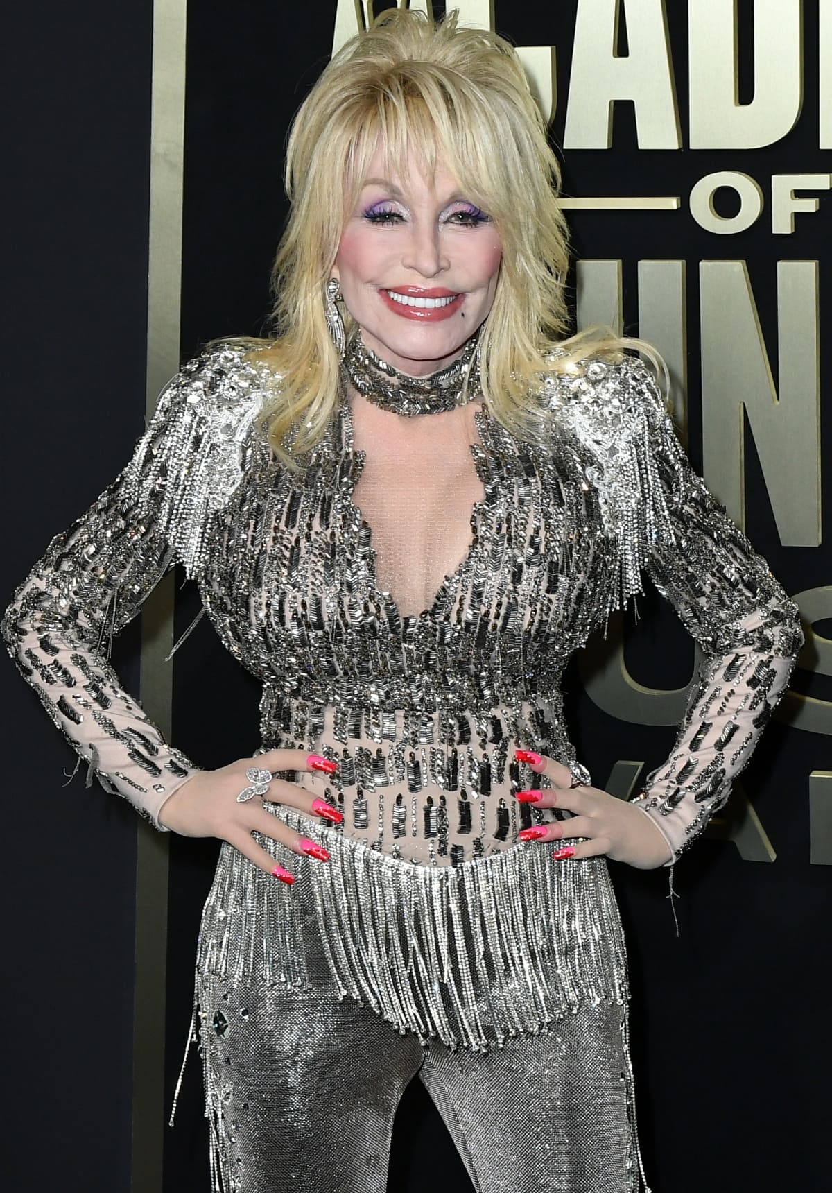 Dolly Parton opted for a pink-and-red manicure to add bold pops of color to her shimmery silver ensemble