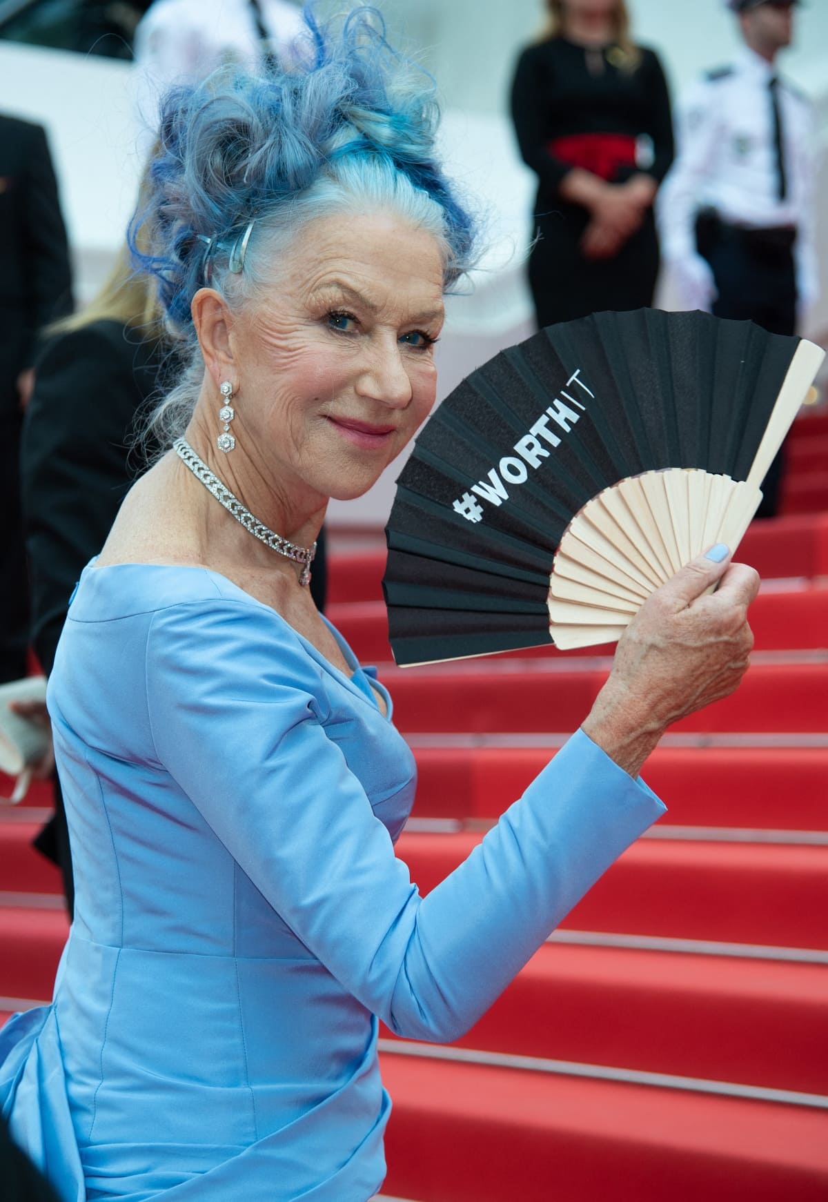Helen Mirren cheekily held up a fan inscribed with the words #WorthIt from L’Oreal’s tagline