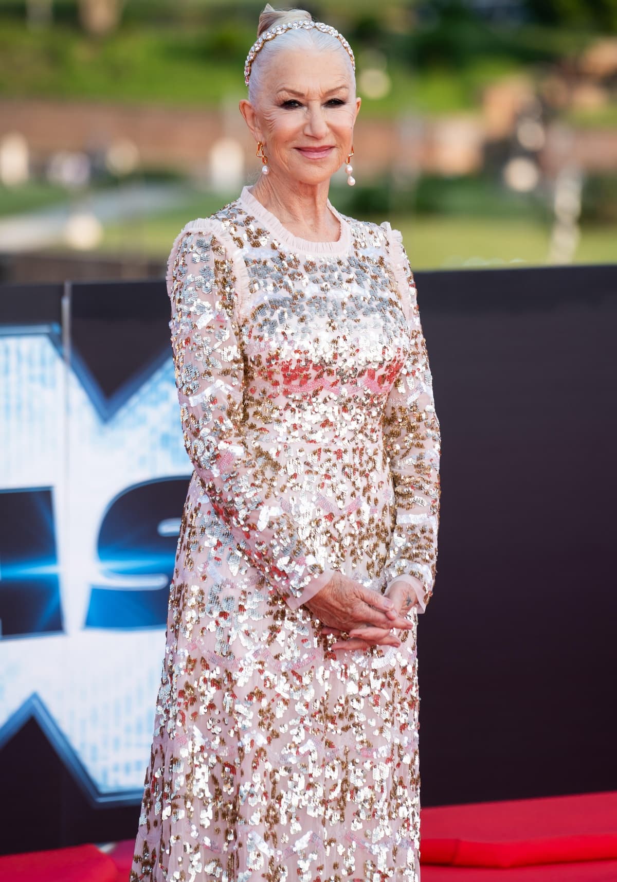 Helen Mirren looking every bit the regal queen that she is with an embellished gown, a flawless beauty look, and a flashy silver tiara