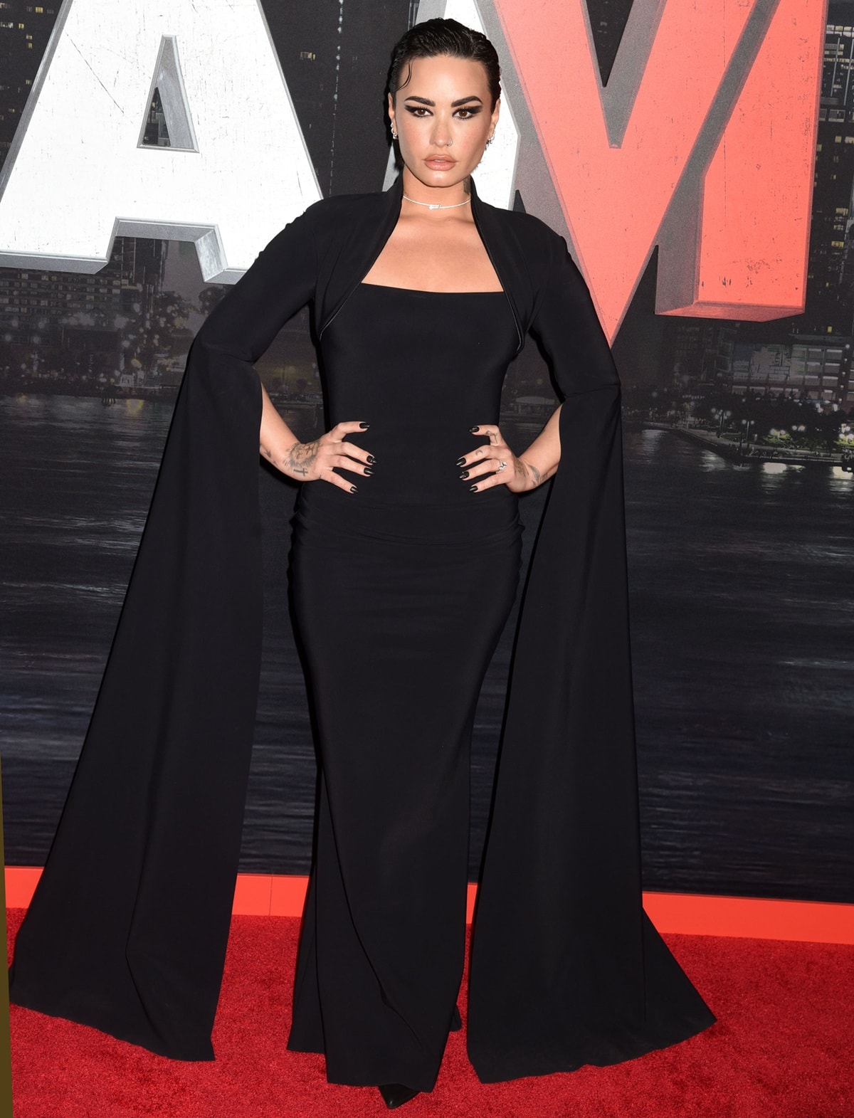 Demi Lovato showcased a stunning Gothic ensemble in a captivating gown crafted by the renowned designer Chiara Boni La Petite Robe featuring a mandarin collar, a figure-hugging mermaid-style silhouette, and exquisite long cape shawl sleeves
