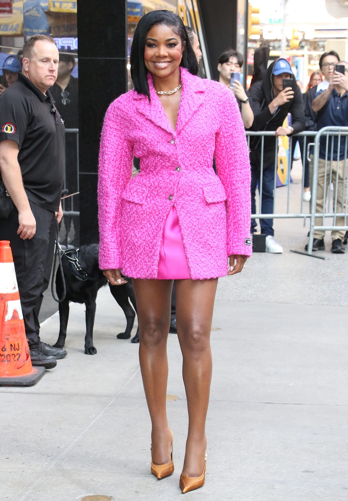 Gabrielle Union leaves Good Morning America studios in a hot pink boucle coat and a matching satin mini skirt by Versace on June 13, 2023
