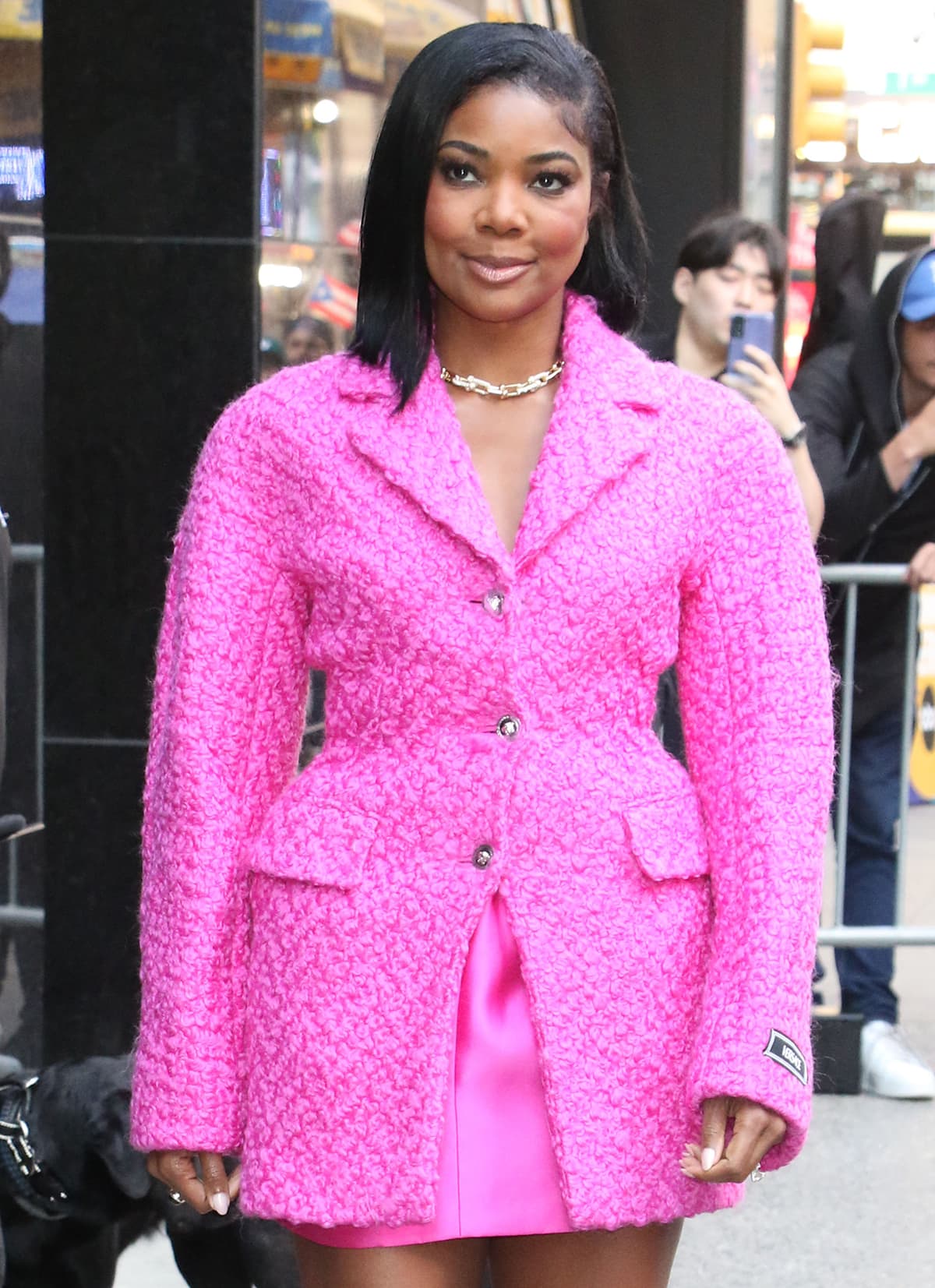 Gabrielle Union pairs her pink ensemble with a Tiffany & Co. chain link necklace, a side-swept hairstyle, and nude lip gloss