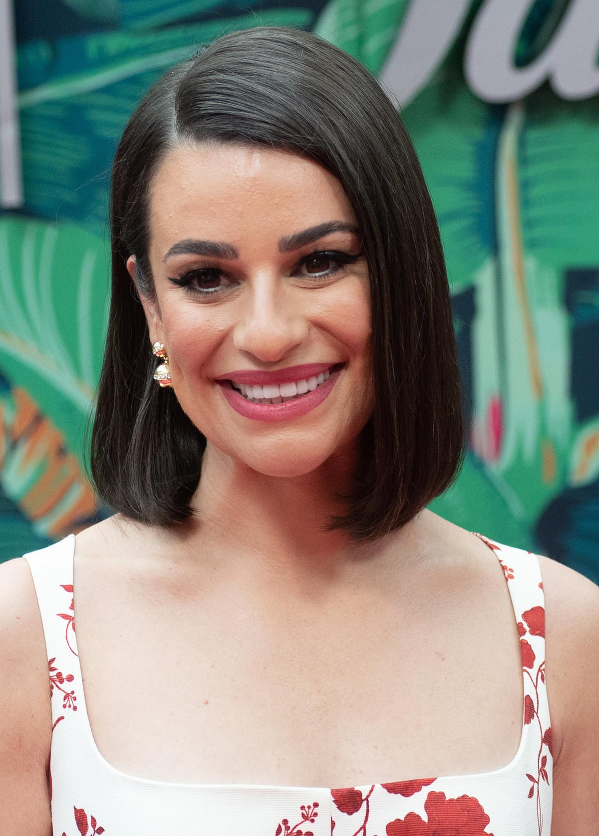 Lea Michele parts her tresses to one side and wears dramatic eyeshadow and fluttery eyelashes to highlight her brown eyes