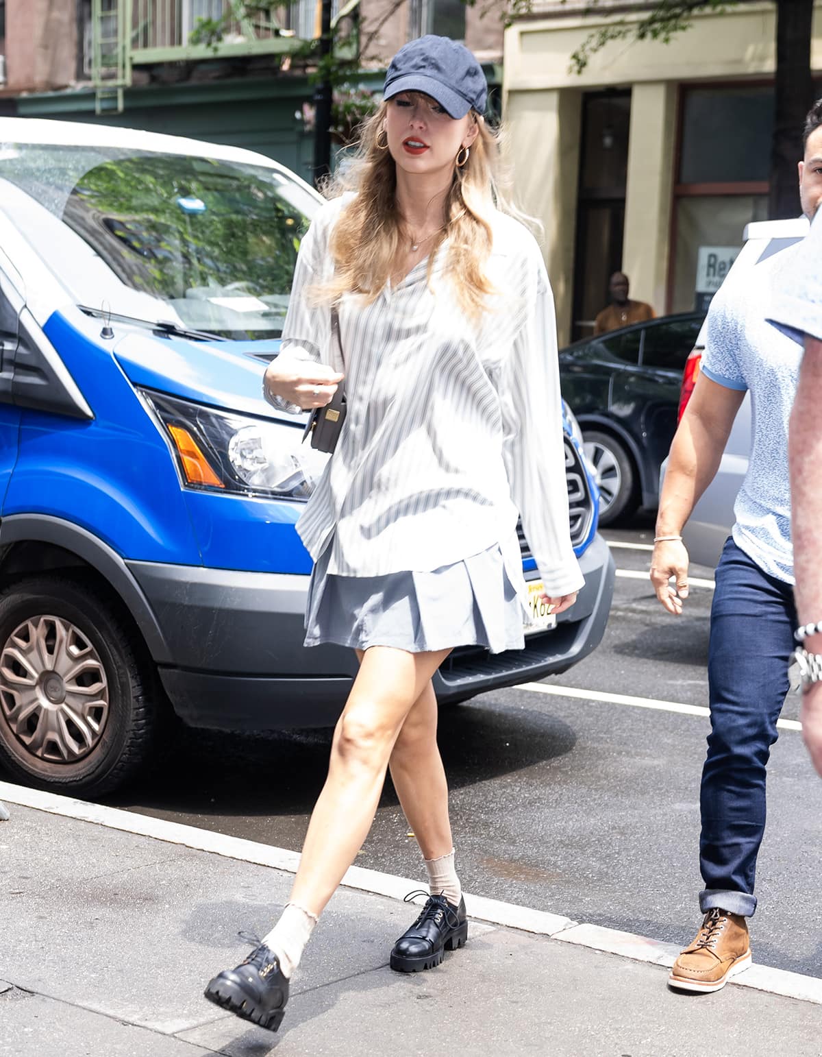 Taylor Swift is summer chic in a striped shirt by The Row, pleated skort by Free People, and chunky black shoes by Malone Souliers