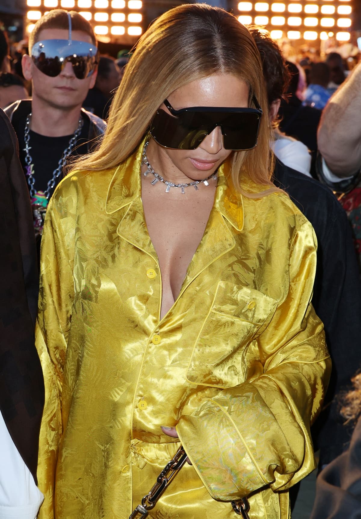 Beyonce wearing a custom golden pajama set from Louis Vuitton accessorized with oversized shield sunglasses, a diamond choker, and a Tiffany & Co. ring
