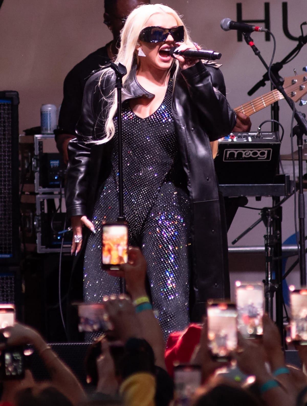 Christina Aguilera embraced a rock-star attitude with a black patent leather jacket and shield-like sunglasses as she performed for an enthusiastic crowd